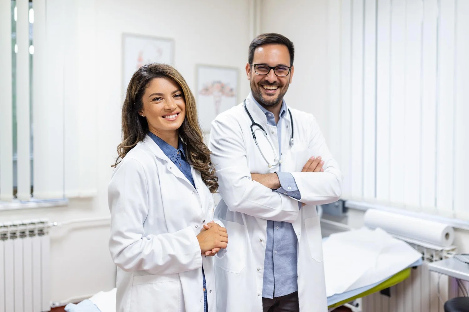 Smiling male and female doctors standing together in a medical office