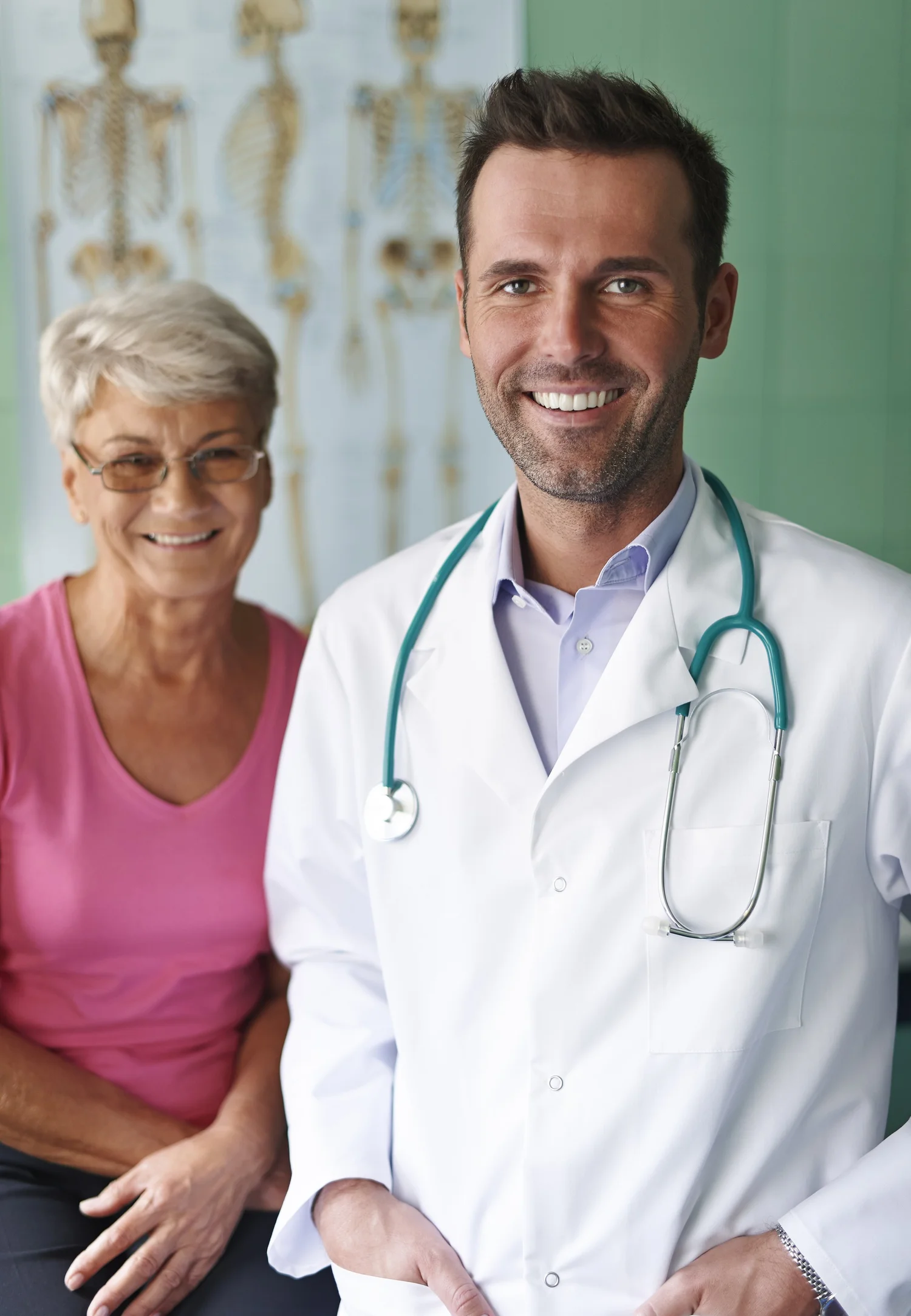 Smiling doctor with a stethoscope consulting with an elderly patient