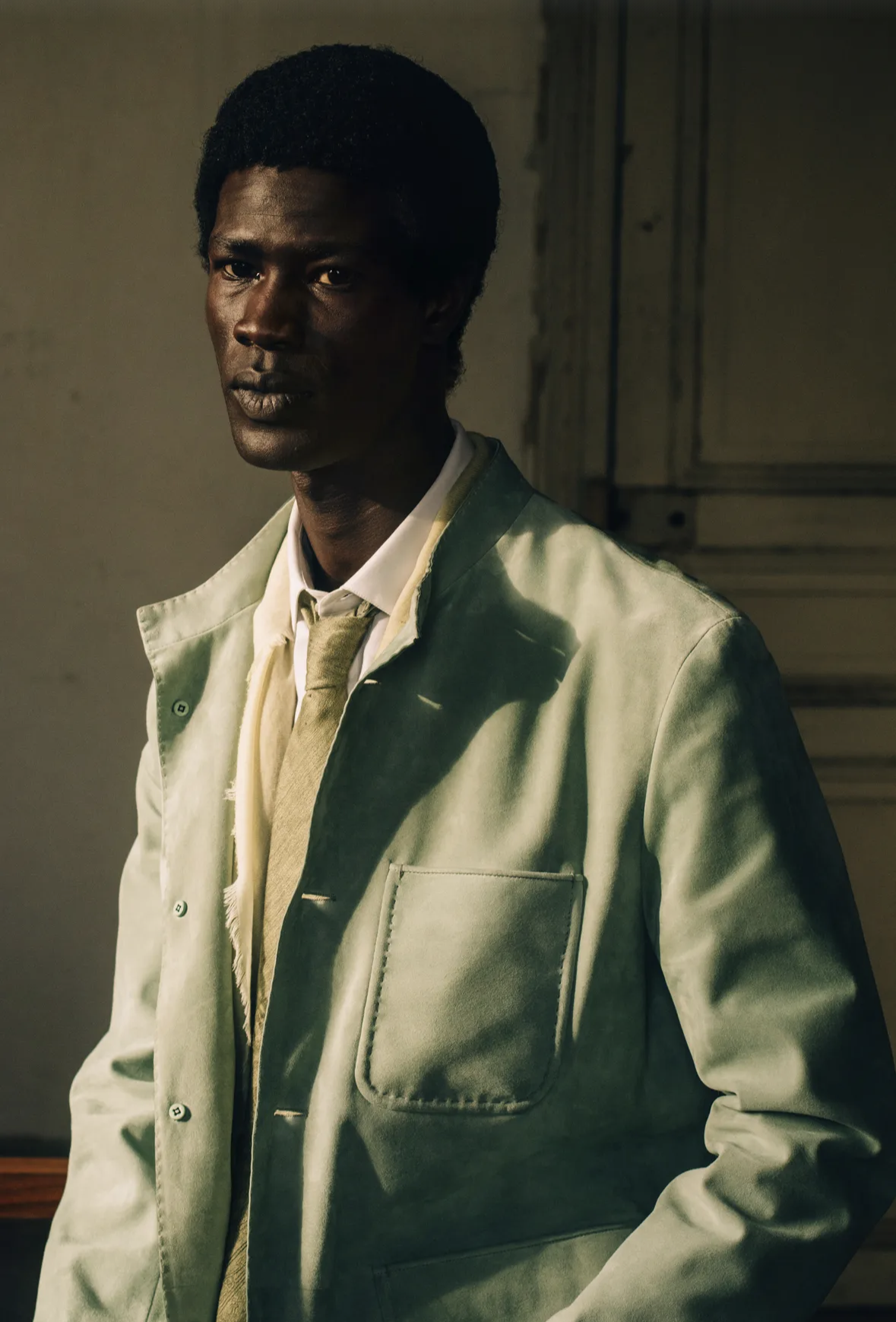 Portrait of a man in a pale green jacket and tie