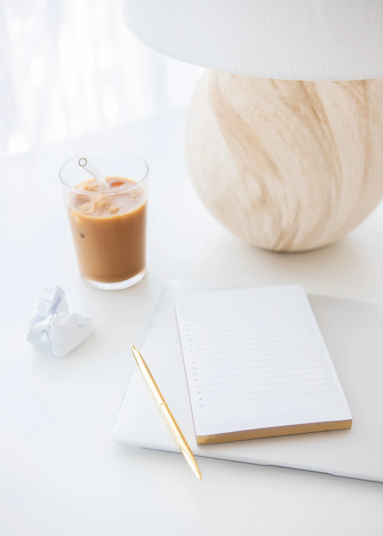 Woman's desk with open notebook, gold pen, and iced coffee — journaling and biblical mindset tools for emotional healing and self-discovery