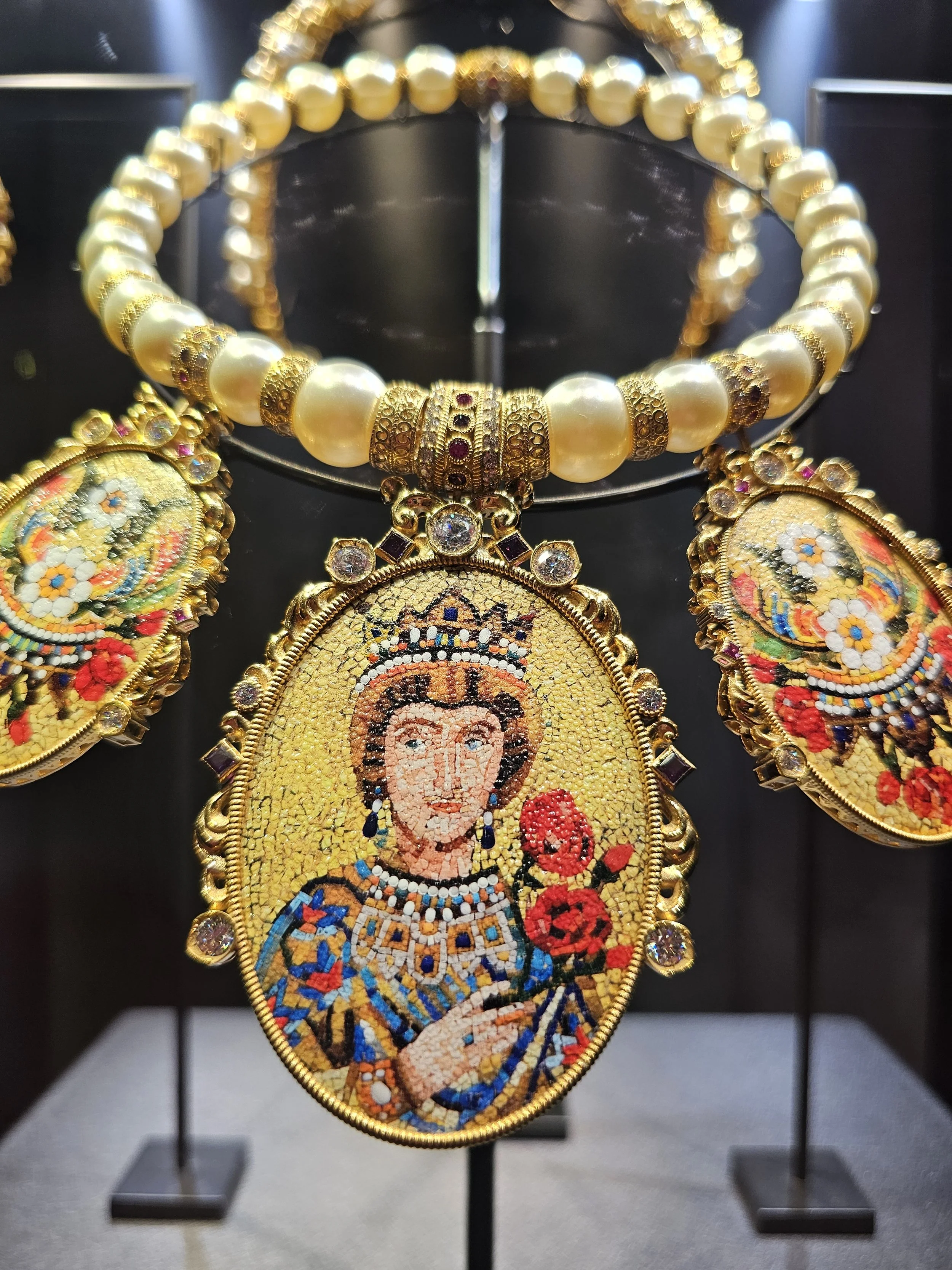 a gold necklace with a face on it