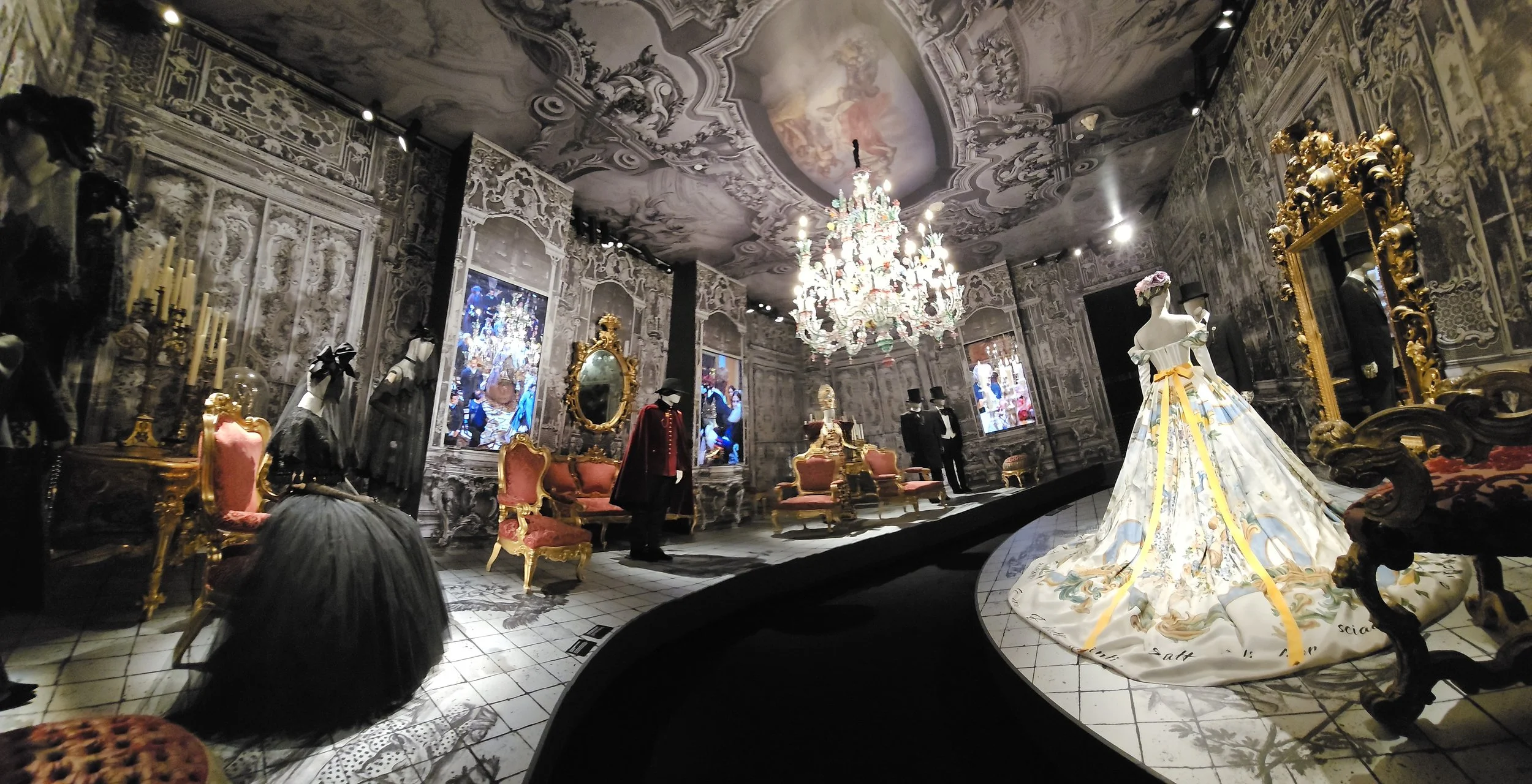 a horizontal panoramic capturing the scene and the ceiling with a black carpet down the middle