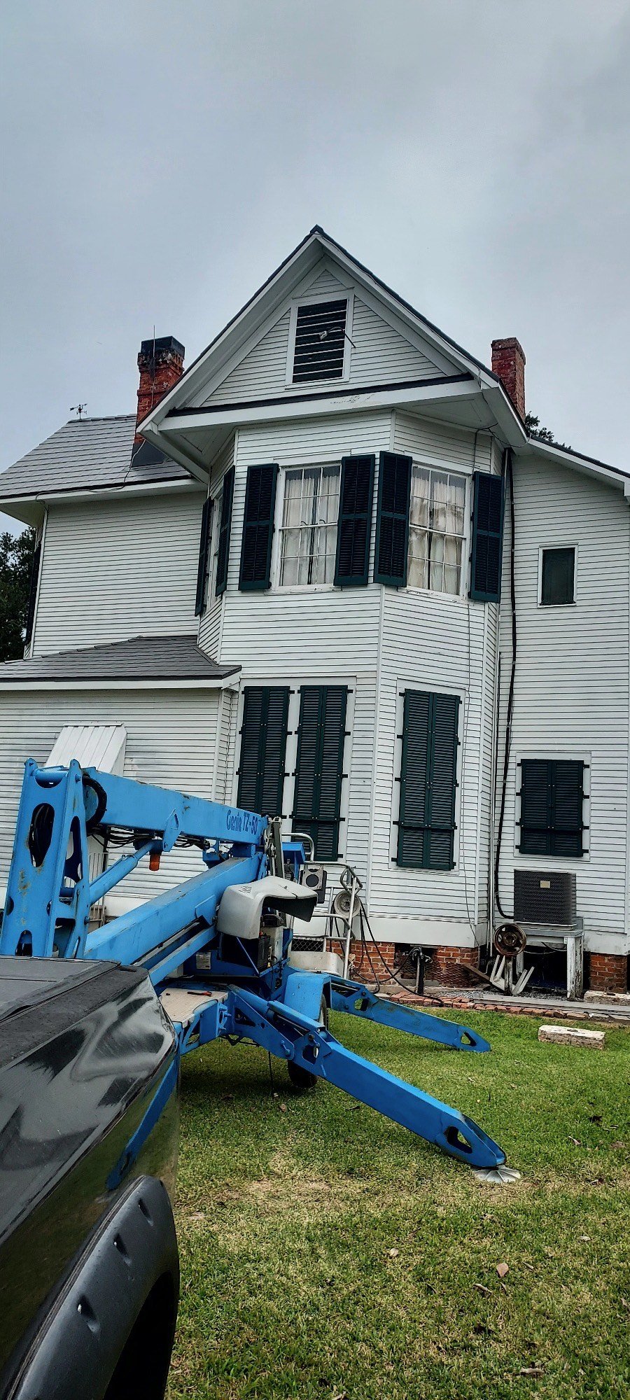 Distance view of storm shutter installation. Top floor shows storm shutters in open position, bottom floor shows them in the closed and fastened position. (1-3)