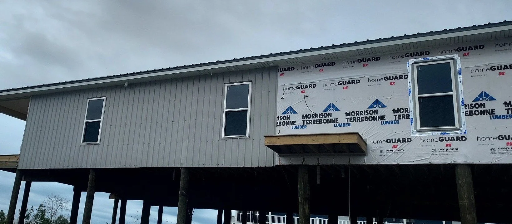 Raised fishing camp with corrugated metal walls & roofing. Windows were also installed by Southern Independent Applicators, LLC (1-4)