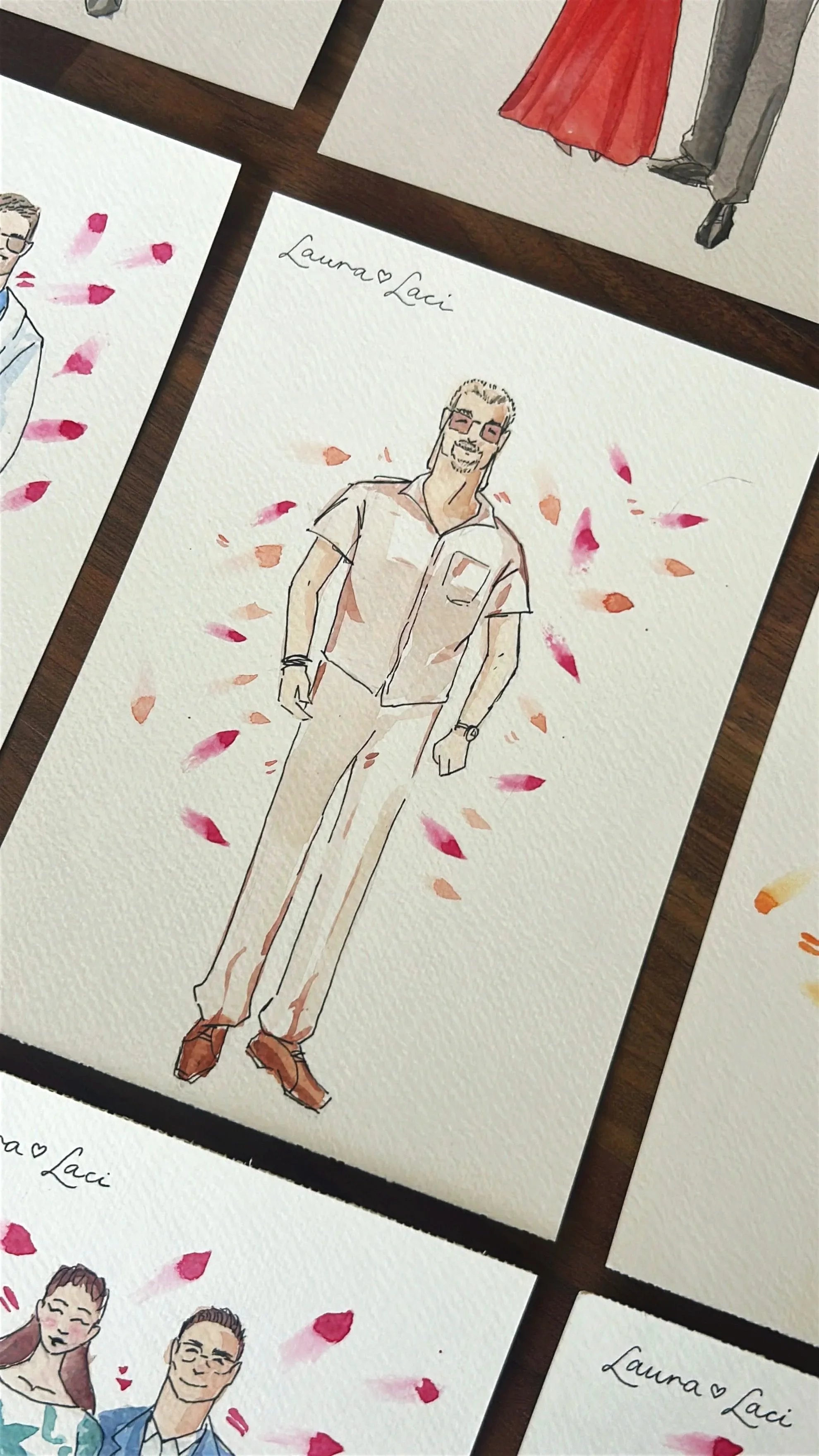 Watercolor illustration of a man with gray hair, glasses, and a beard, wearing a cream short-sleeve shirt and tan pants, surrounded by pink and orange petals, with the handwritten text 'Laura & Laci' above.