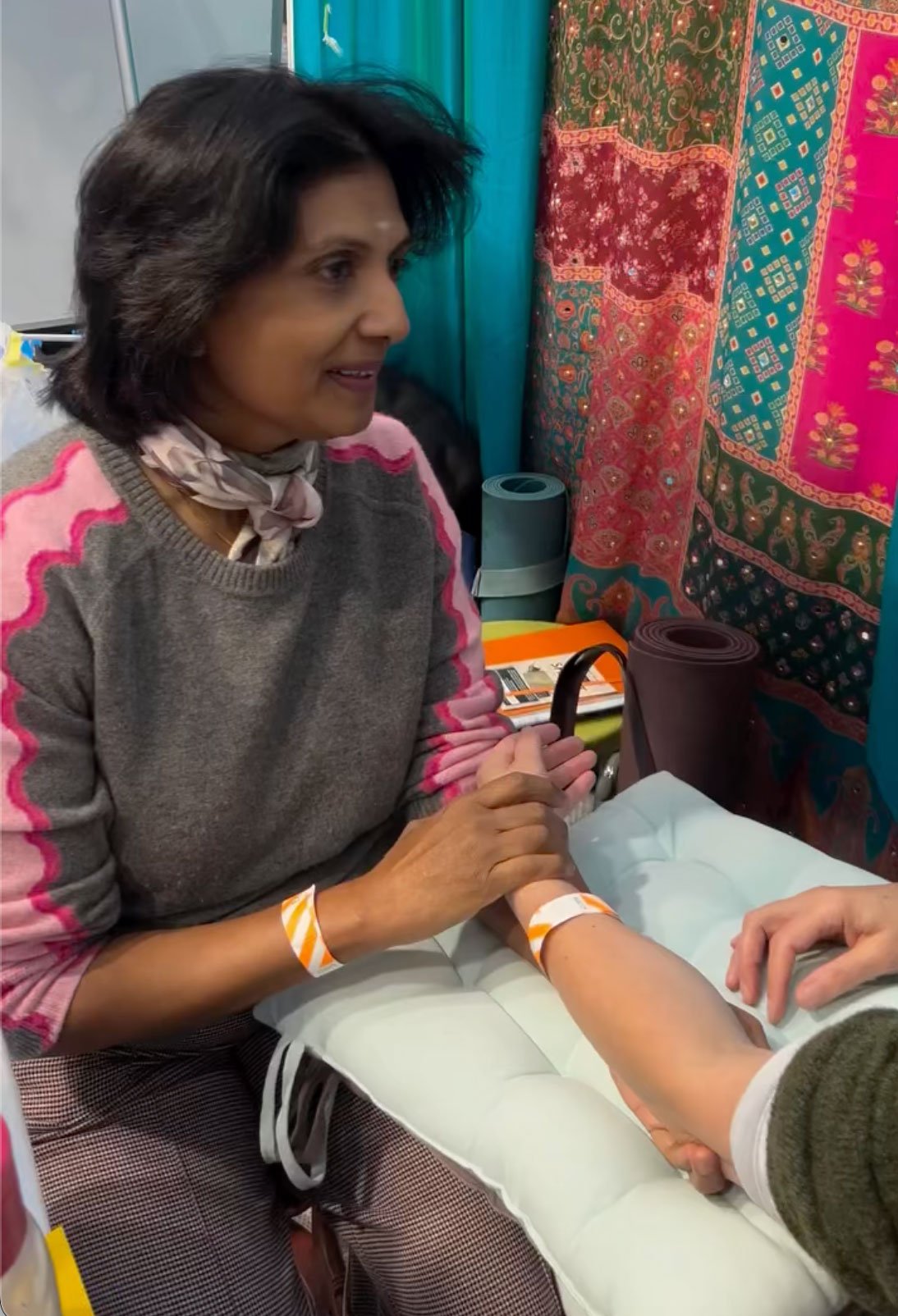 Ayurvedic pulse reading consultation in West London clinic with practitioner smiling