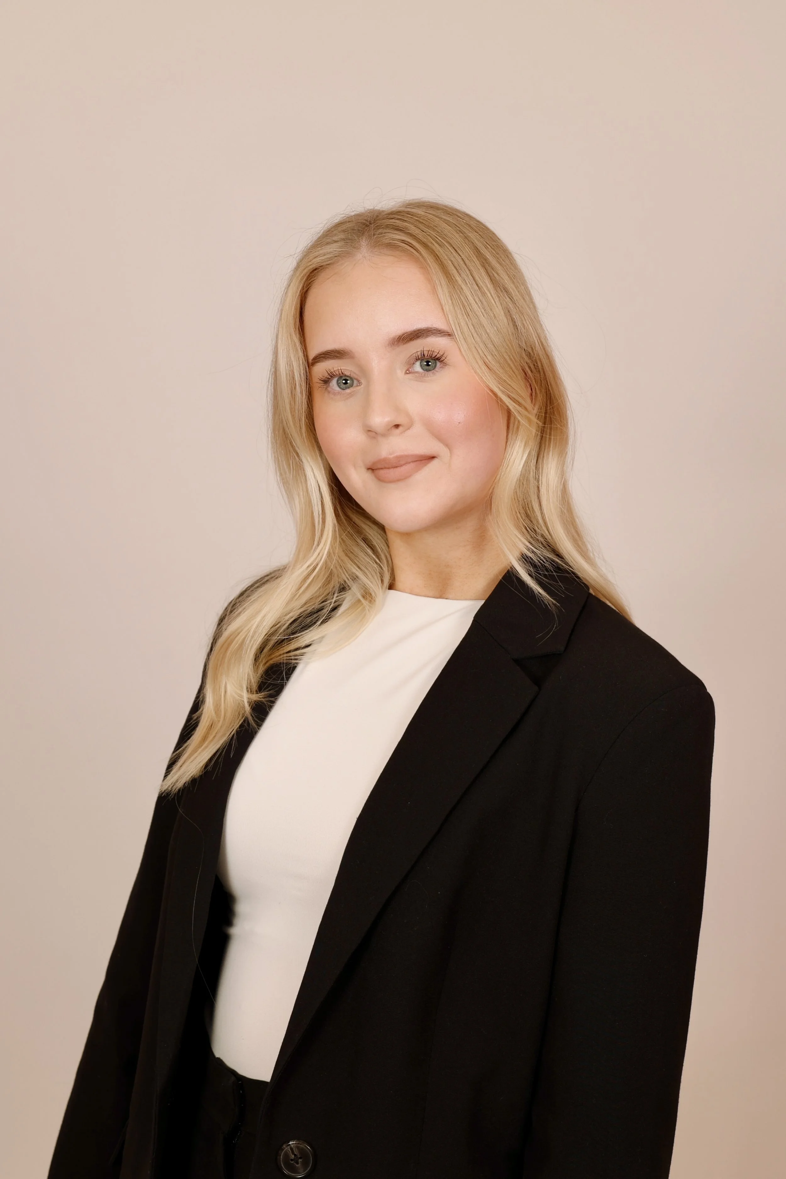 Mustavalkoinen valokuva naisesta. Hän on pukeutuneena mustaan puseroon, taustalla valkoinen seinä.