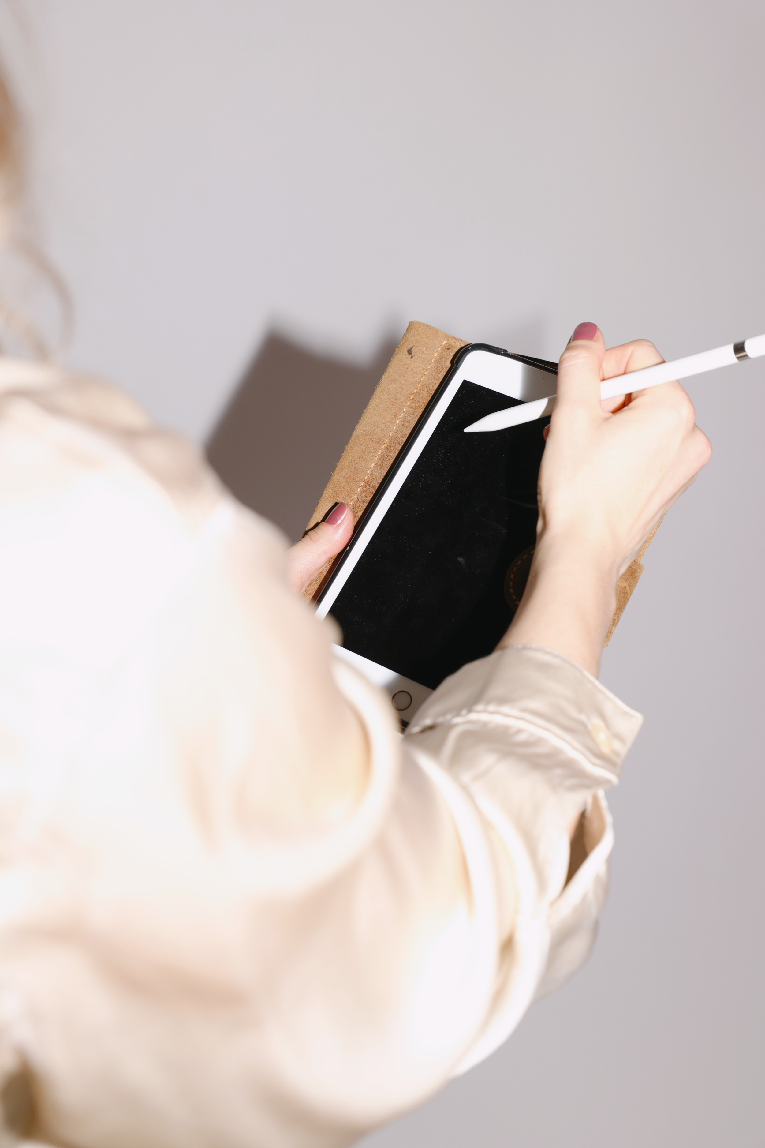 Olkapään takaa otettu kuva, jossa kirjoitettavan tablettiin