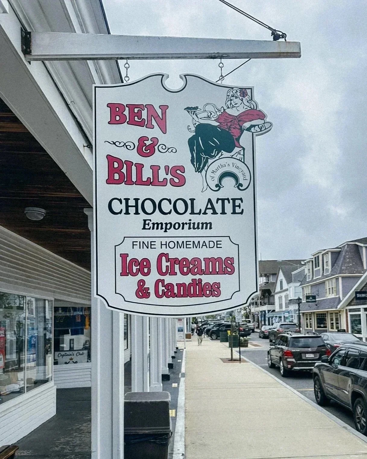 Sign for Ben & Bill's Chocolate Emporium that offers homemade ice creams and candies, featuring a vintage-style illustration of a woman holding a tray of ice cream.