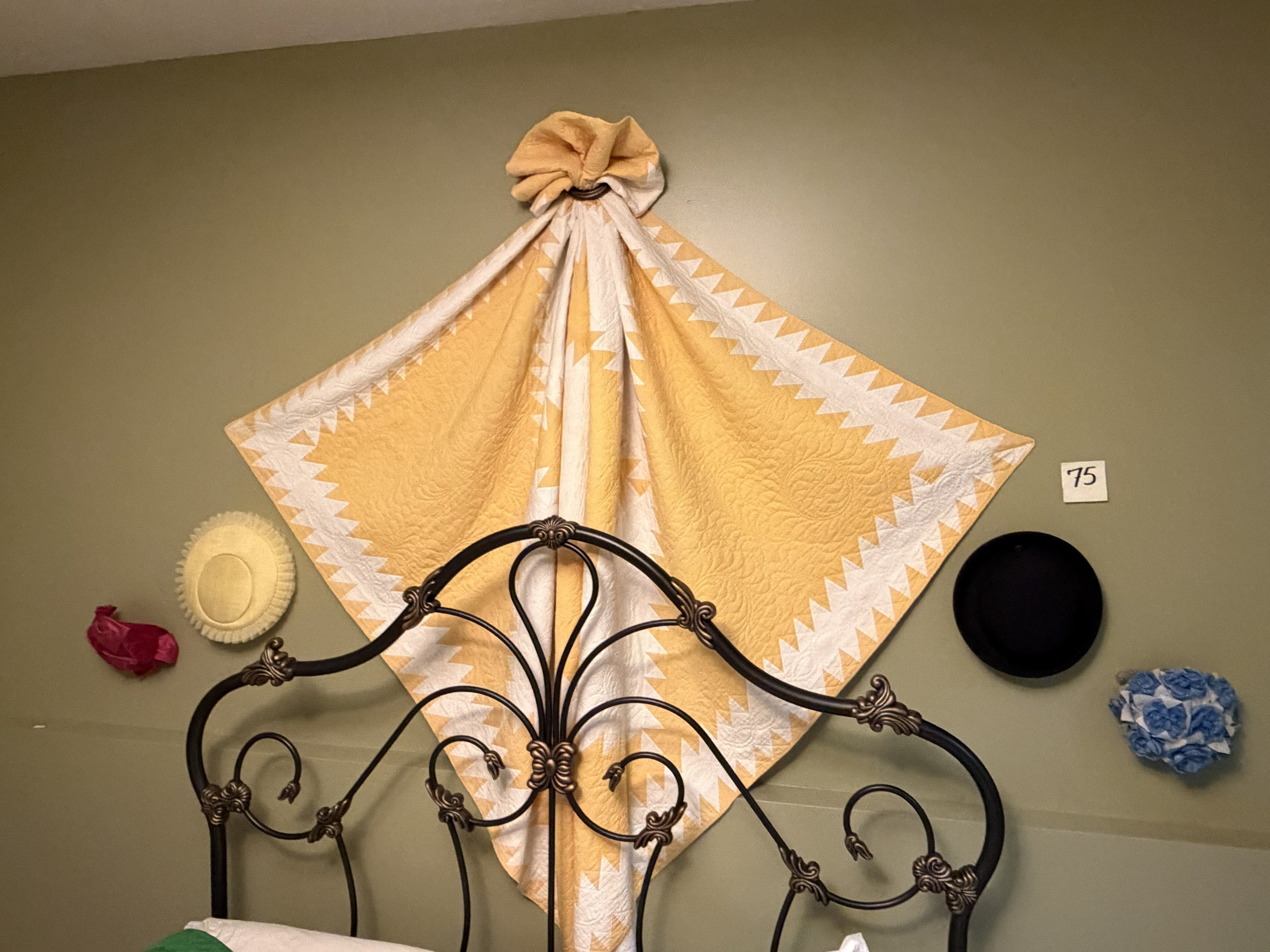 75 Yellow Antique quilt & hats display.jpg