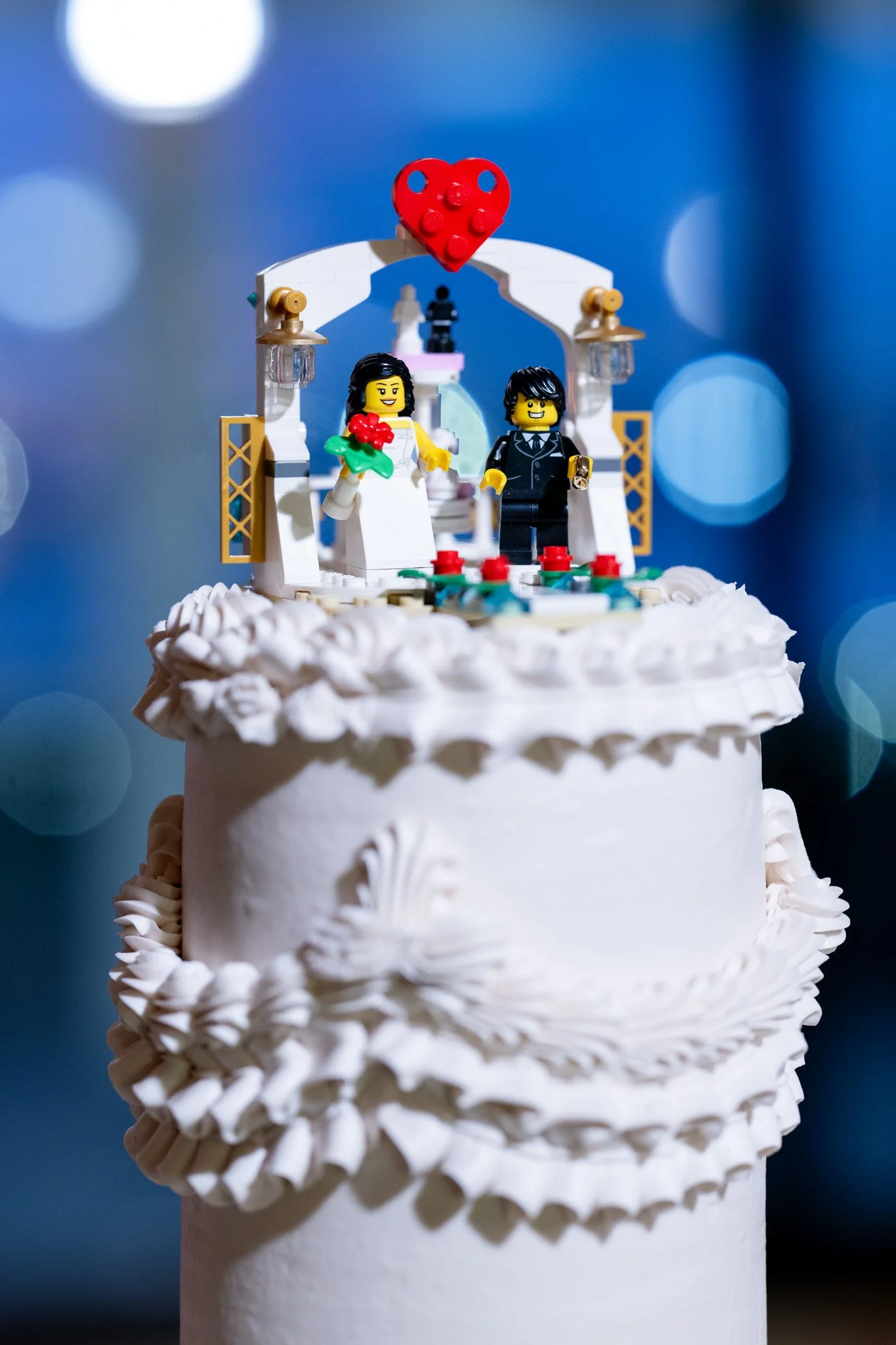 Close-up of a charming Lego chapel wedding cake topper with bride and groom figurines, highlighting the couple's unique touch for a NYC wedding