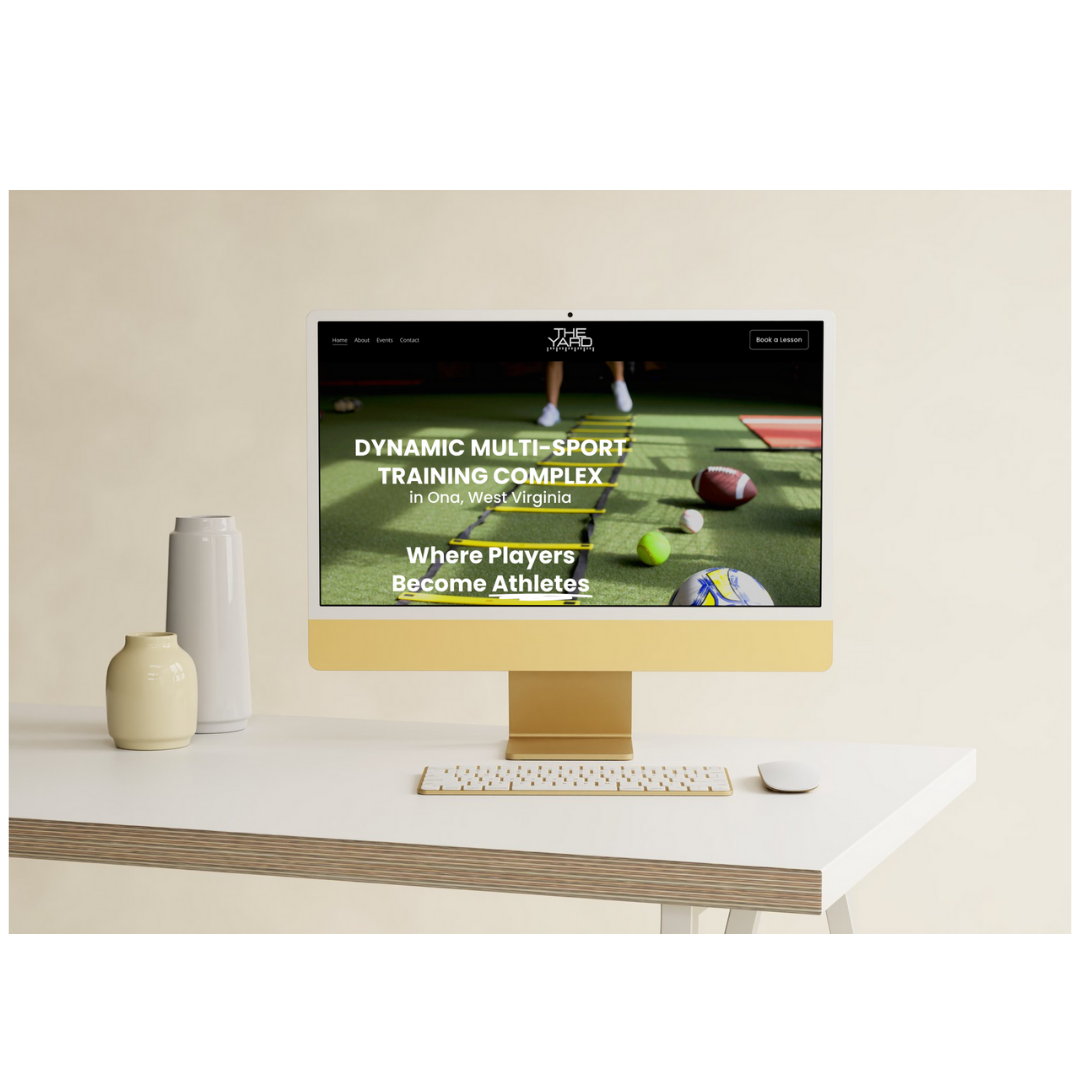 Computer monitor on a white desk displaying a sports training website, with vases and a keyboard nearby.