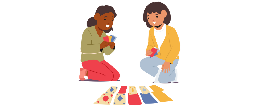 Two kids sitting on the floor playing a card game with a colorful card box in front of them.