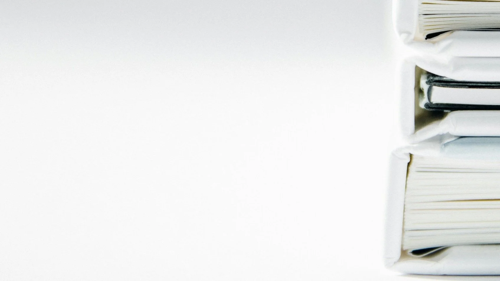 Stack of books with white covers on a white background.