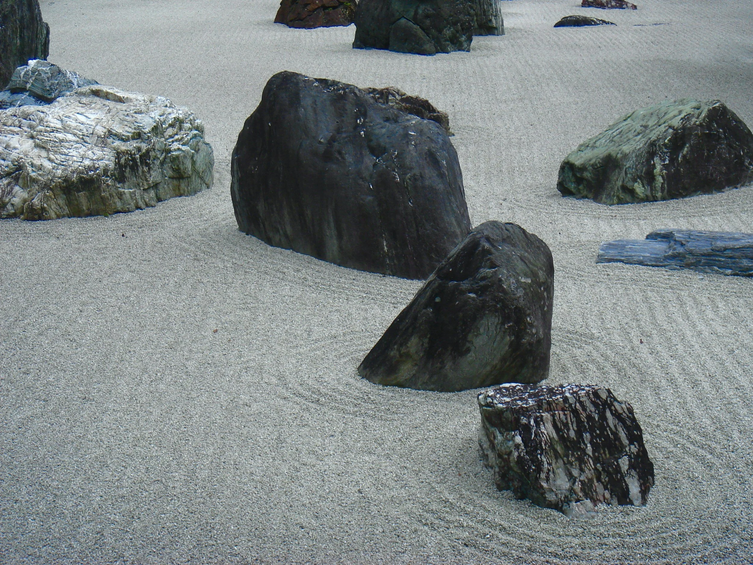 a zen garden made up of fine gravel with statement rocks or boulders in it