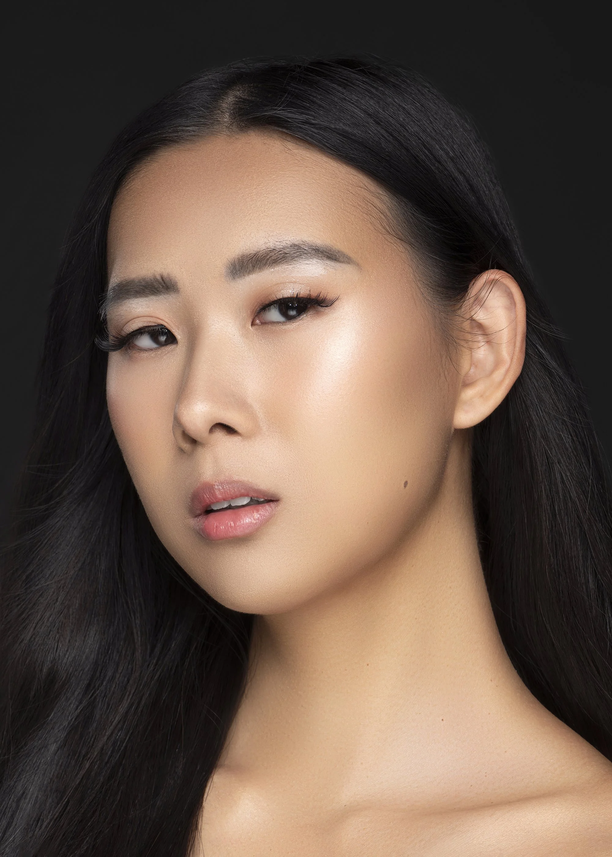 Professional beauty portrait of a model represented by Forward The Agency, photographed at Industry Makeup Academy in Atlanta, Georgia against a dramatic black background. Editorial beauty photography featuring flawless makeup, luminous skin, and pro
