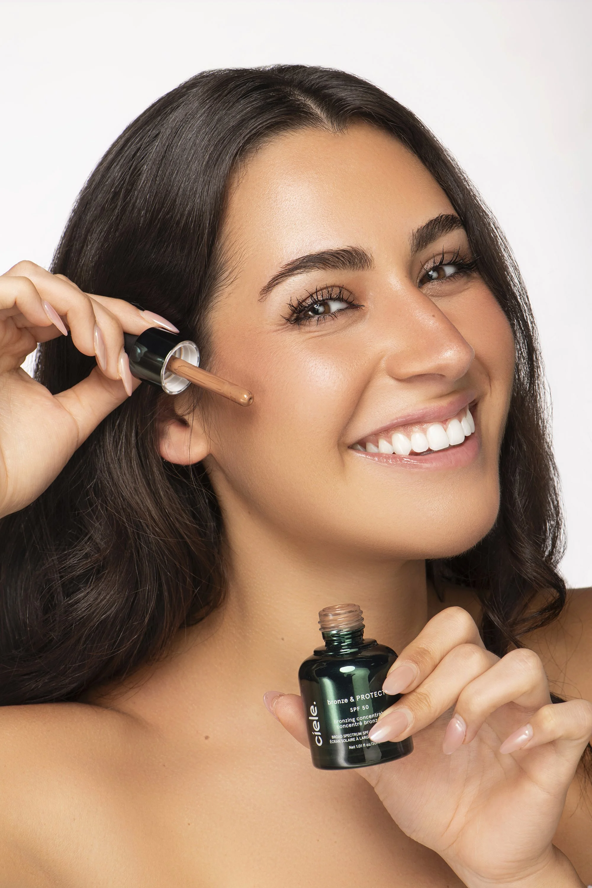 Atlanta commercial and editorial beauty photographer Caitlin Tabilog studio images of Briana Marquez model and actress from Forward the Agency showcasing makeup, lip gloss, and skincare products with professional lighting white and pink background