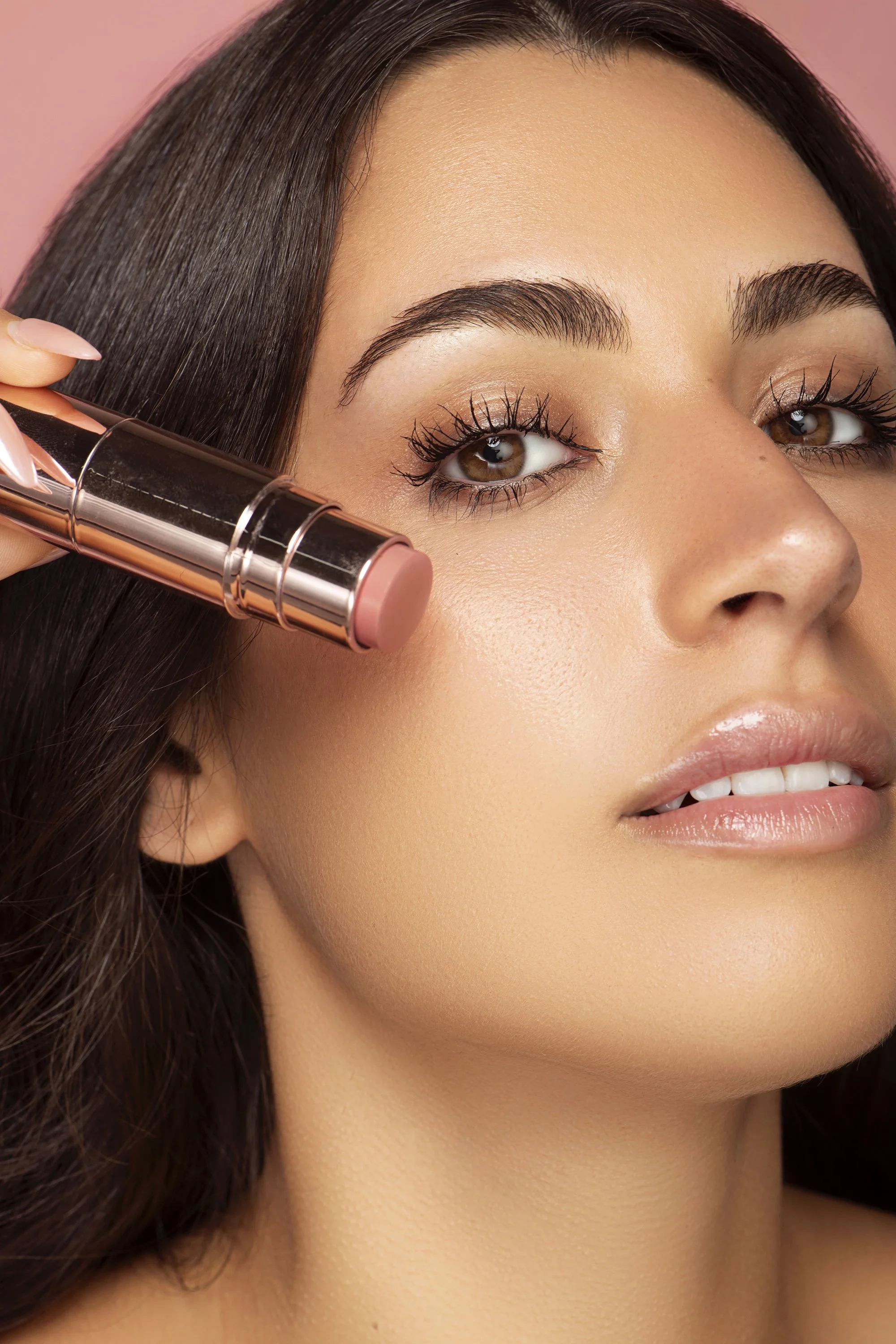 Atlanta beauty and makeup photographer Caitlin Tabilog studio portrait of Briana Marquez model and actress from Forward the Agency with white and pink background featuring lip gloss and skin serum high-end skincare editorial photography