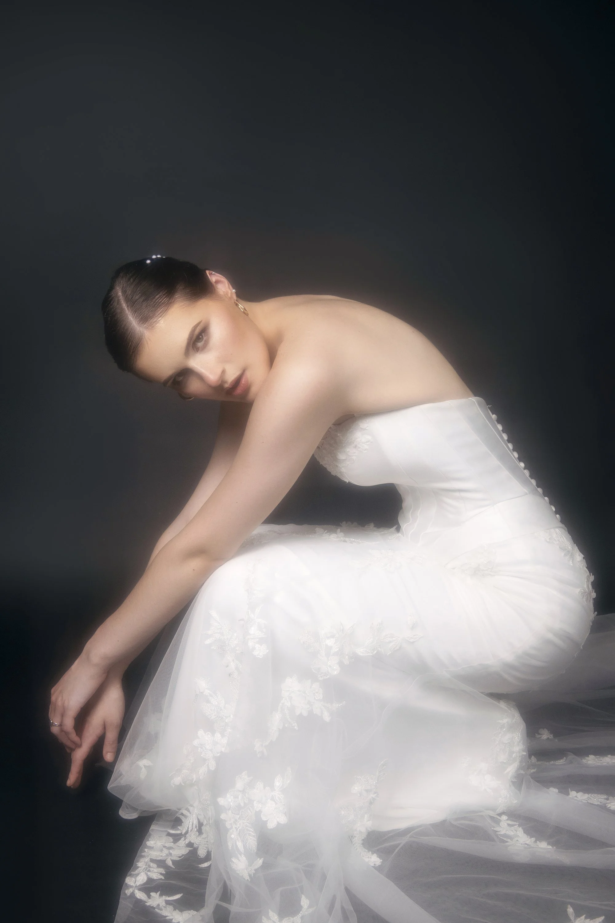 Georgia bridal editorial portrait of Sabrina, a Forward The Agency model, photographed by Atlanta bridal and fashion photographer Caitlin Tabilog in an Anna Christine Bridal wedding gown. The dramatic black backdrop highlights bridal hair by Golden H
