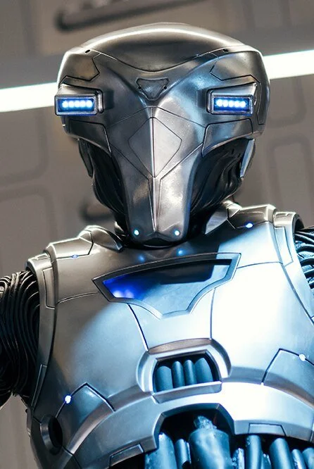 A futuristic humanoid robot with a sleek metallic body and illuminated blue eyes, featuring a helmet-like head and glowing accents.