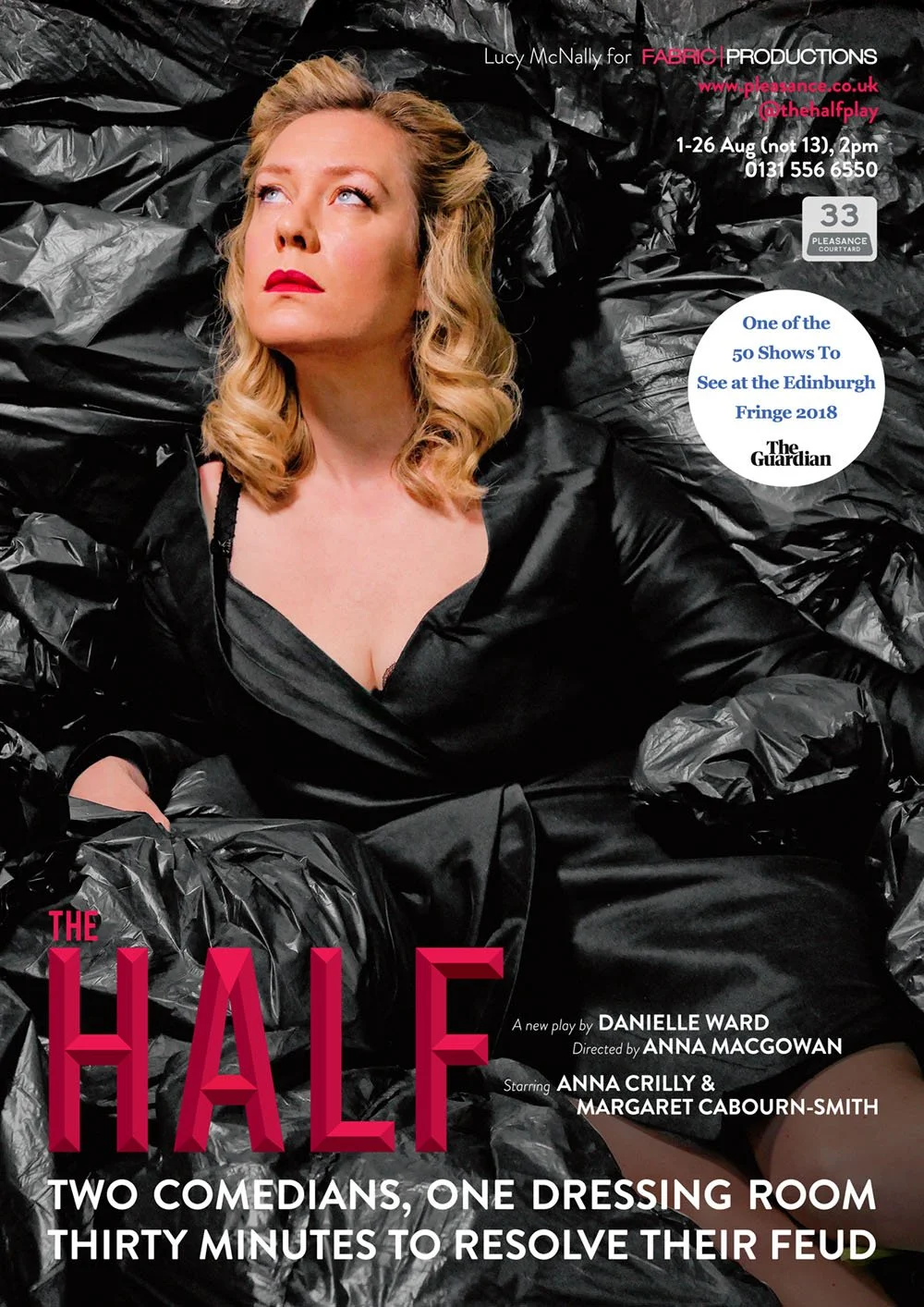 Cover of a playbill for the theatrical production titled "The Half." Features a woman with blonde curly hair and red lipstick, lying among black plastic bags, wearing a black satin dress.