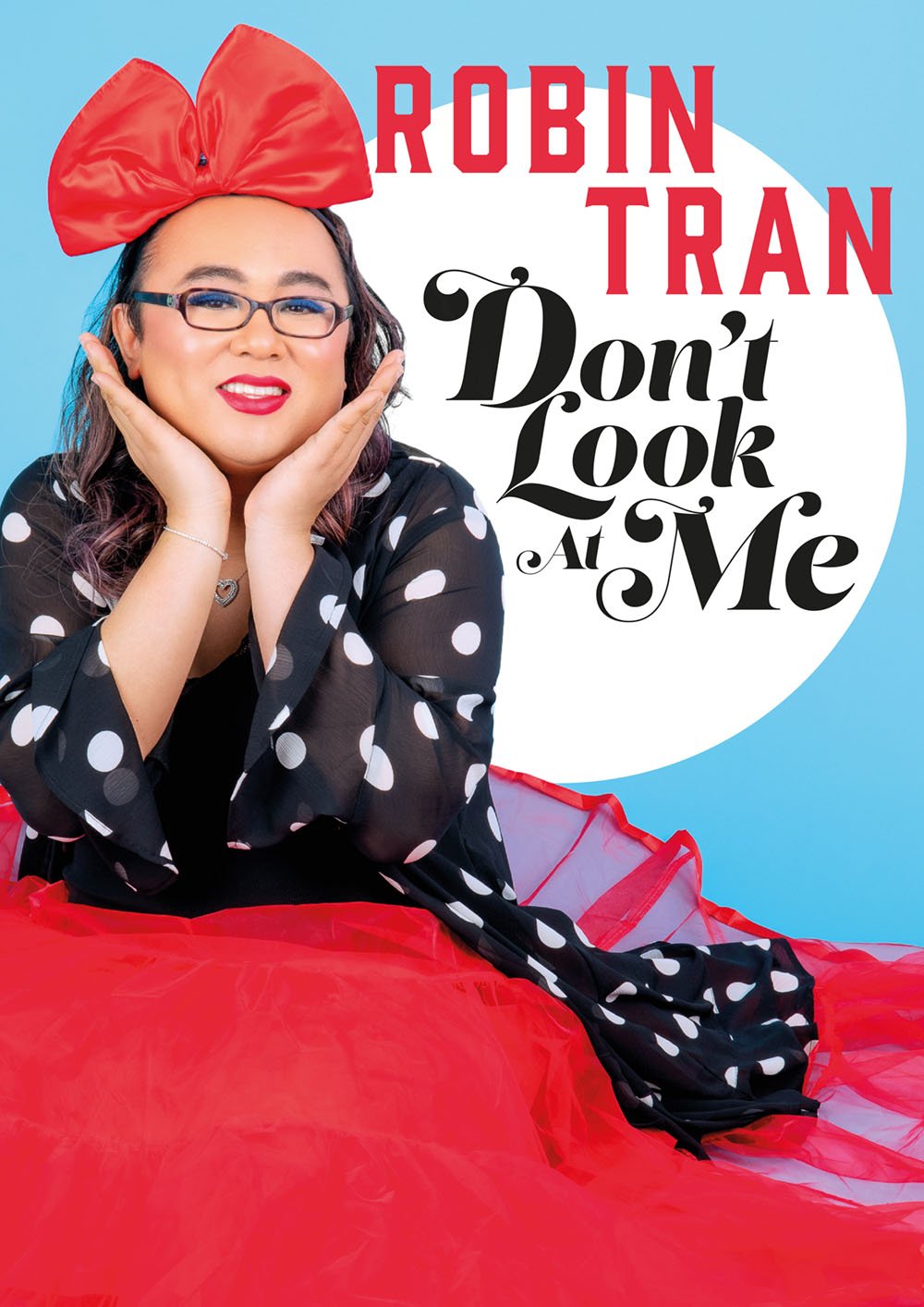 Book cover featuring Robin Tran with glasses, red lipstick, a large red bow on her head, wearing a black and white polka dot top, and a red tulle skirt. The title reads 'Robin Tran Don't Look at Me'.