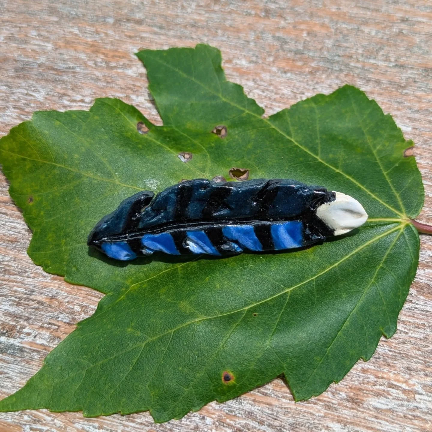 I was greeted by a loud Blue Jay this morning at work and it reminded me how much I love these charming little creatures. 
My new ceramic Blue Jay feather pin is probably one of my favorite pieces. The mixture of blue underglazes turned out wonderful