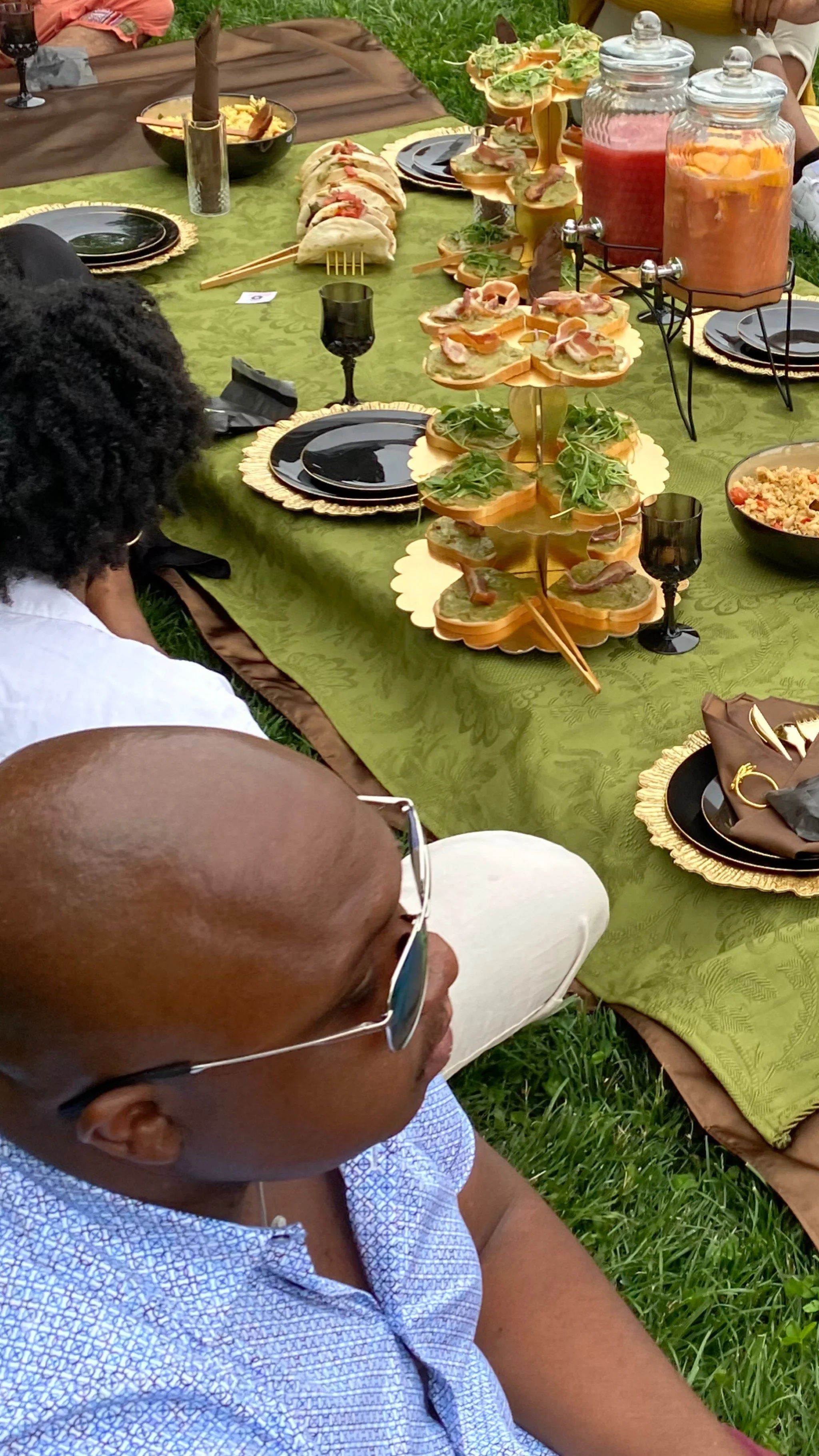 Overhead shot of models and picnic set up with avocado toast tower