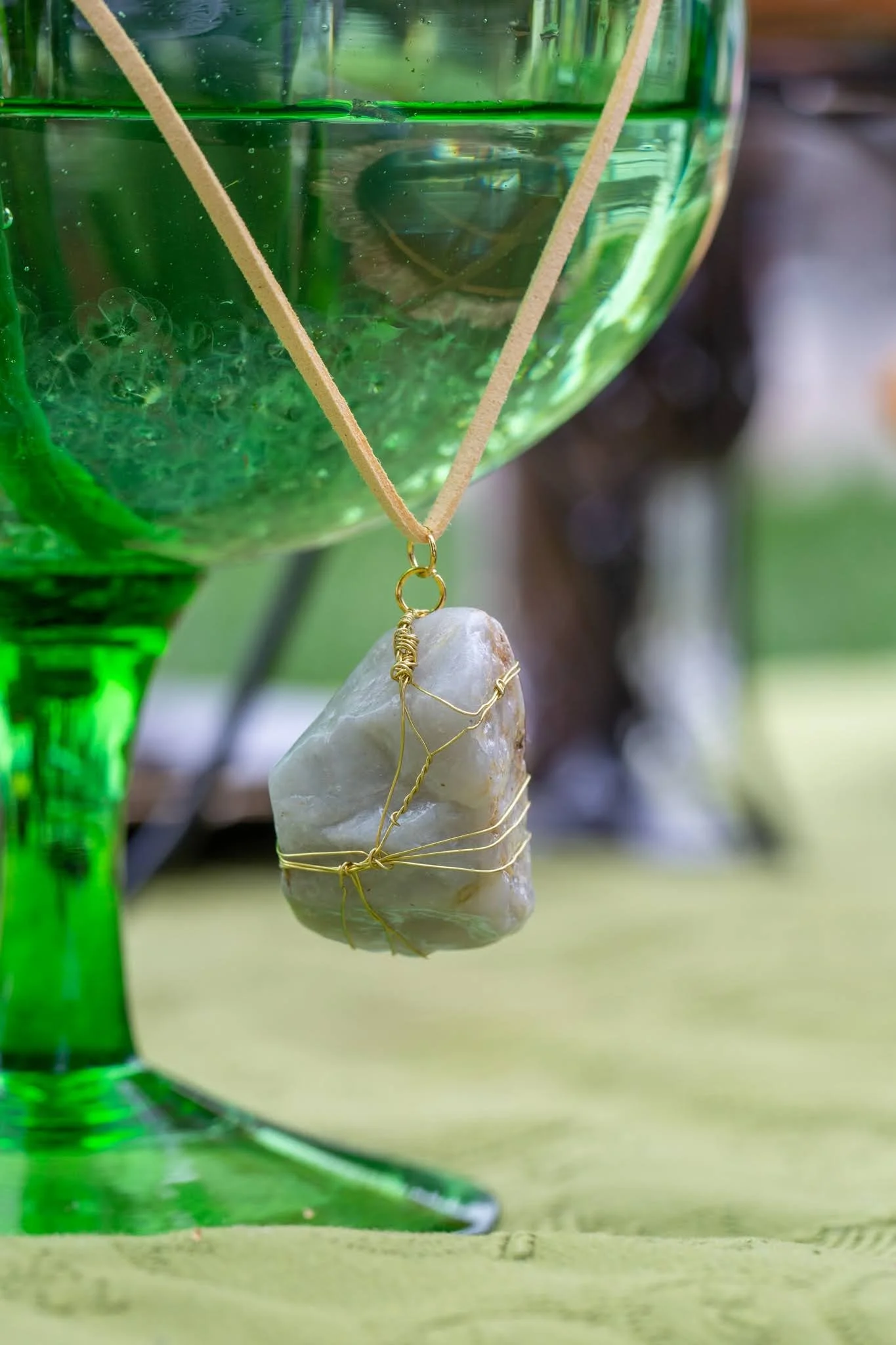 Anjy's Eyes necklace hanging from green vase