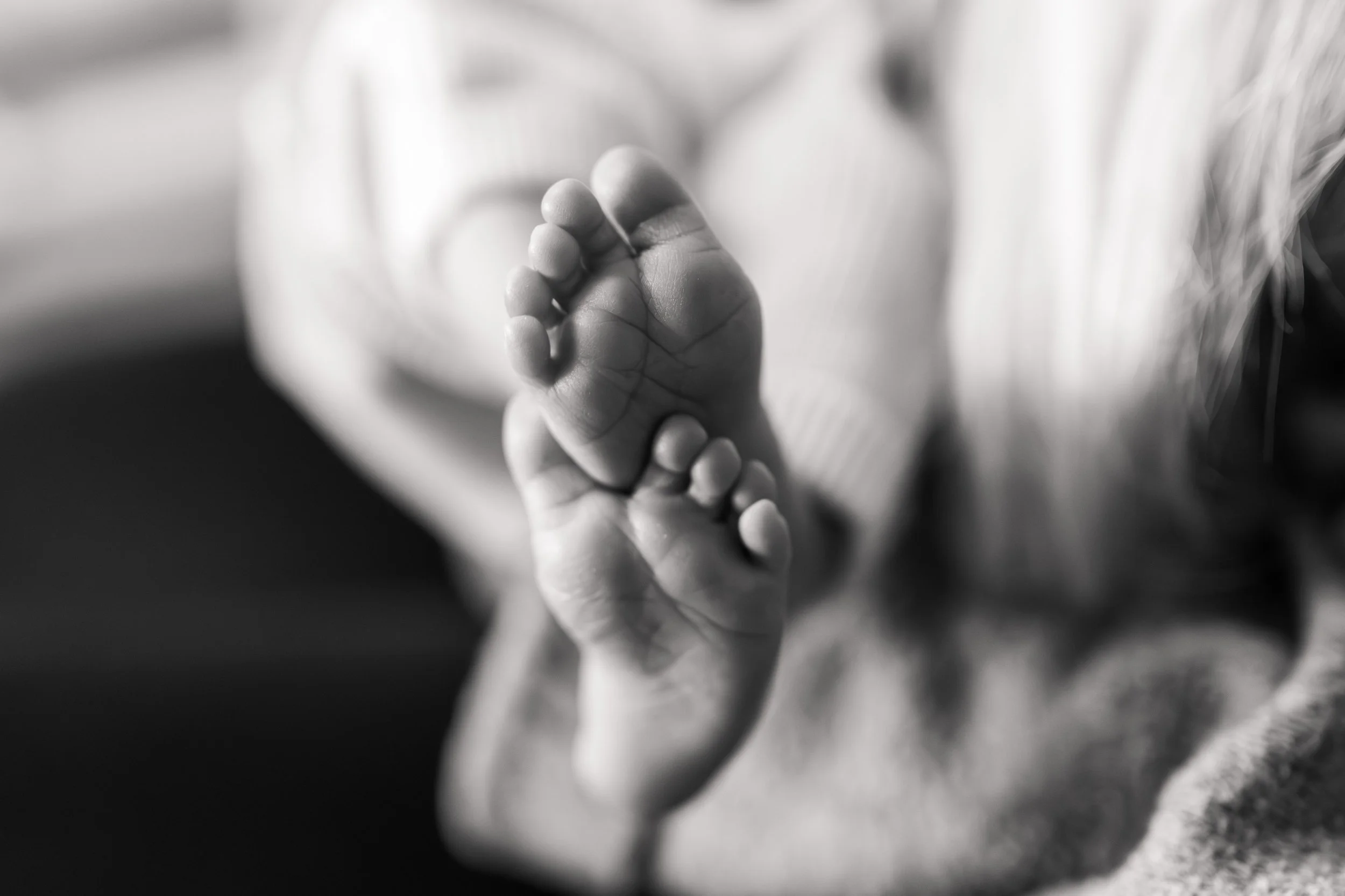 Nahaufnahme eines Babys, das seine Hand hält.
