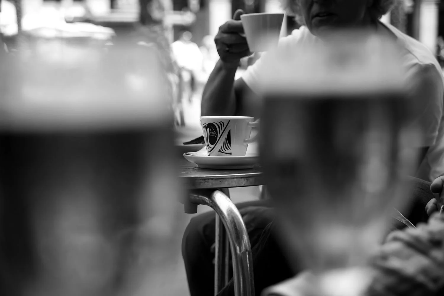 A cup of coffee raised in conversation during a quiet café moment.
Barcelona