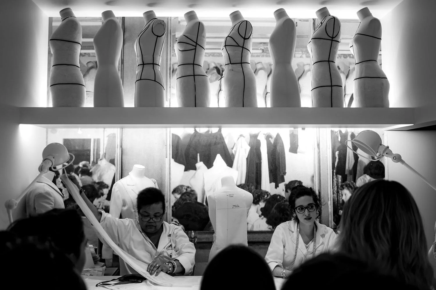 Visitors observe a demonstration of couture craftsmanship, revealing the workshop process behind Dior’s creations.
