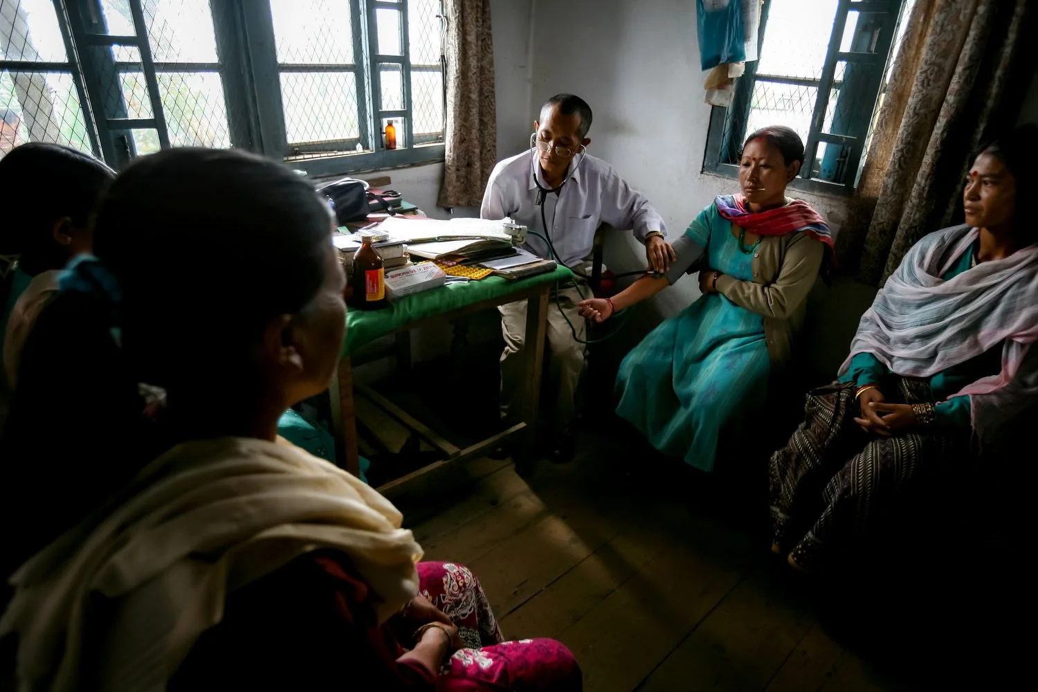 A doctor conducts a health check-up for tea garden workers.