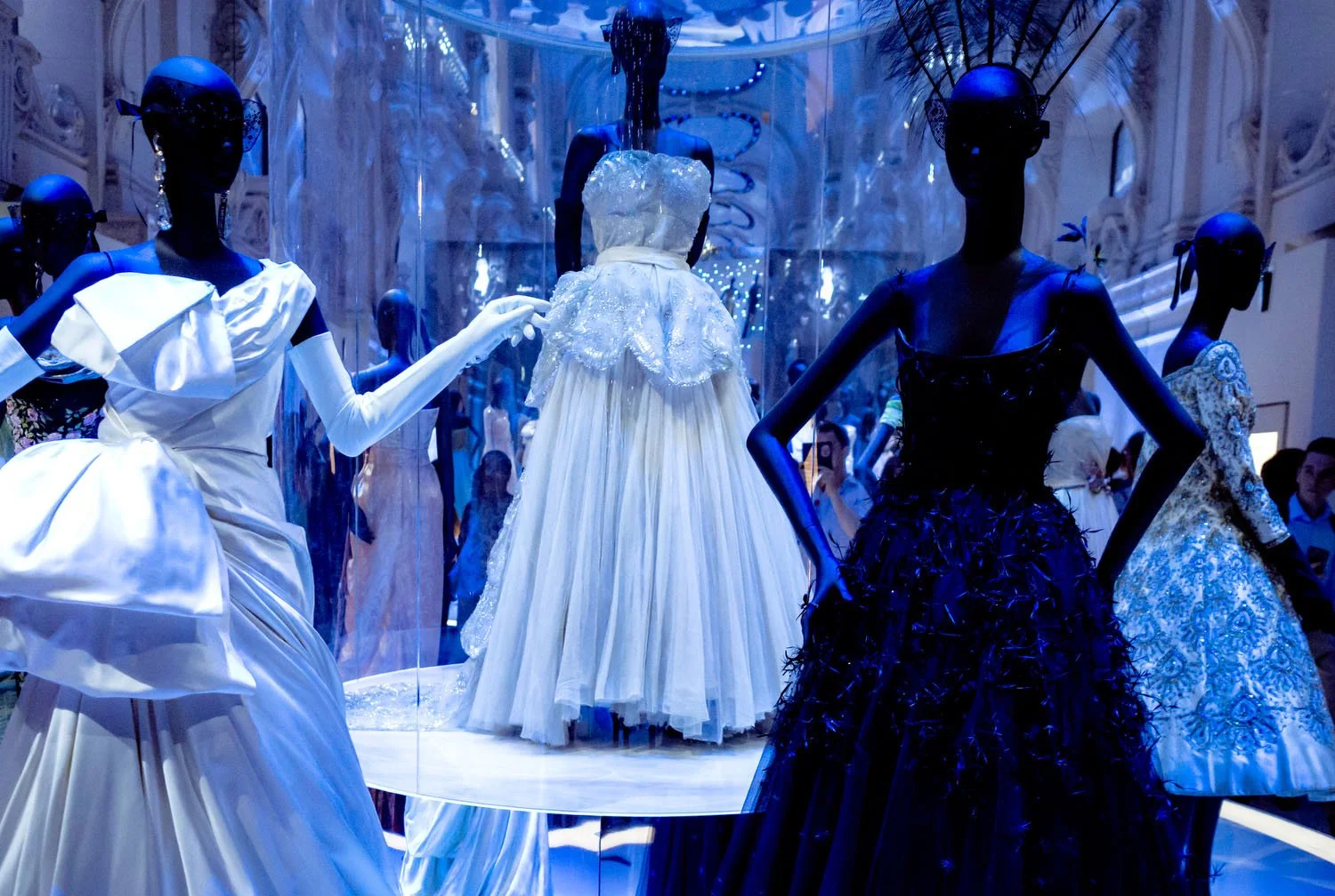 Visitors encounter Dior silhouettes in a gallery space designed to emphasize elegance and form.