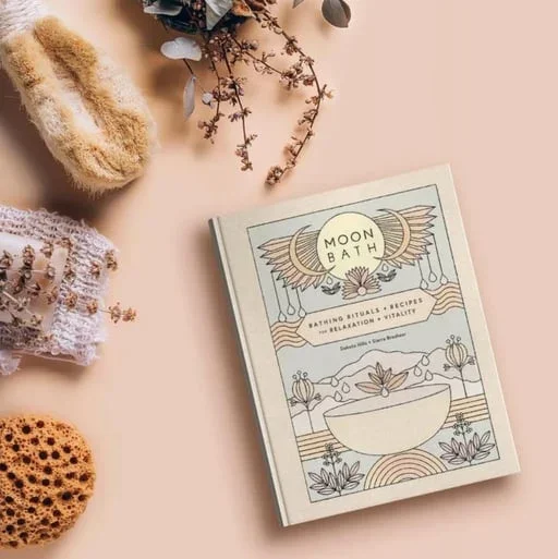 A ritual bathing book surrounded by dried botanicals