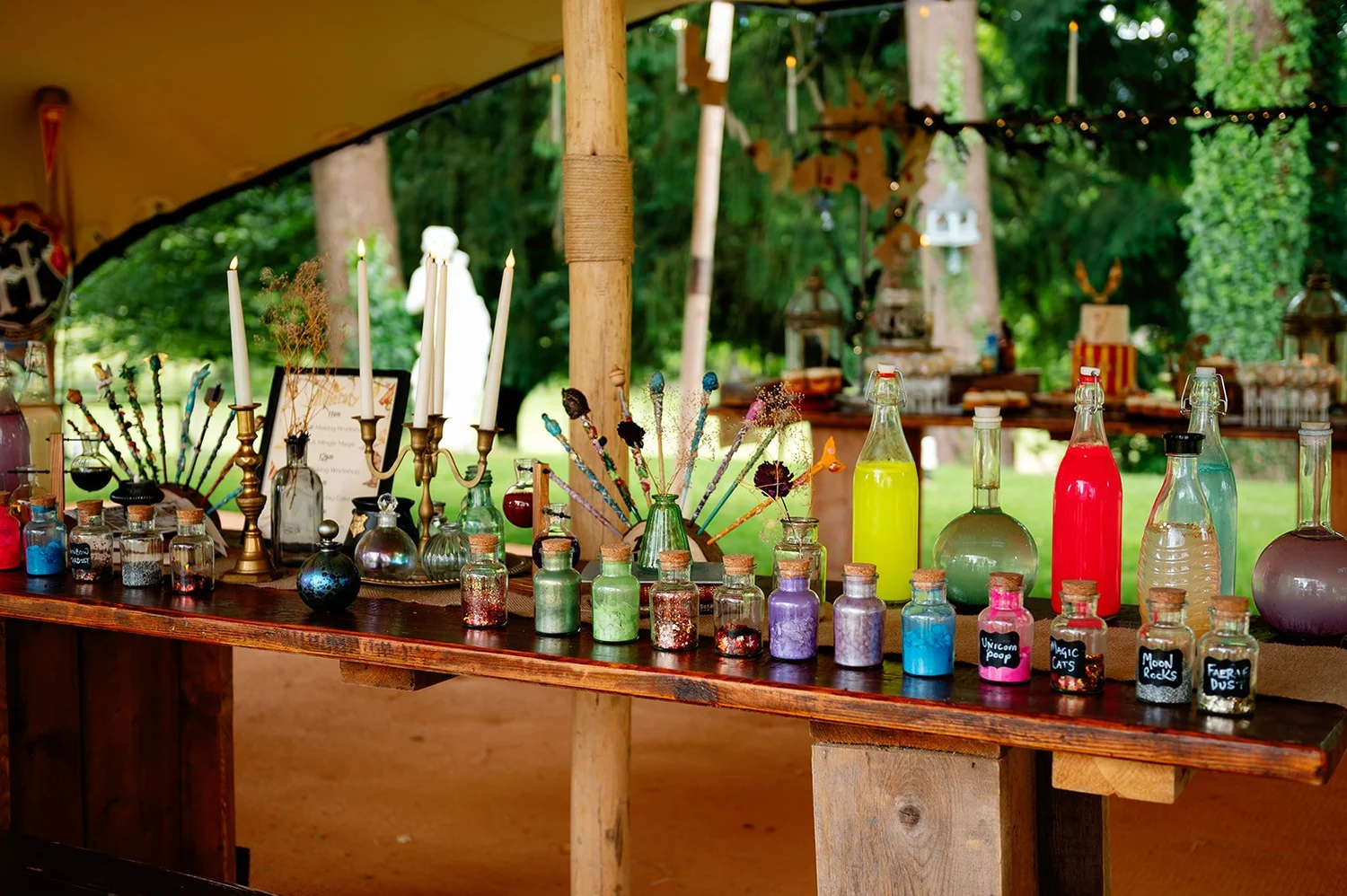 The Conkers potion table, crowded with jars of glitter, candles and handmade wands