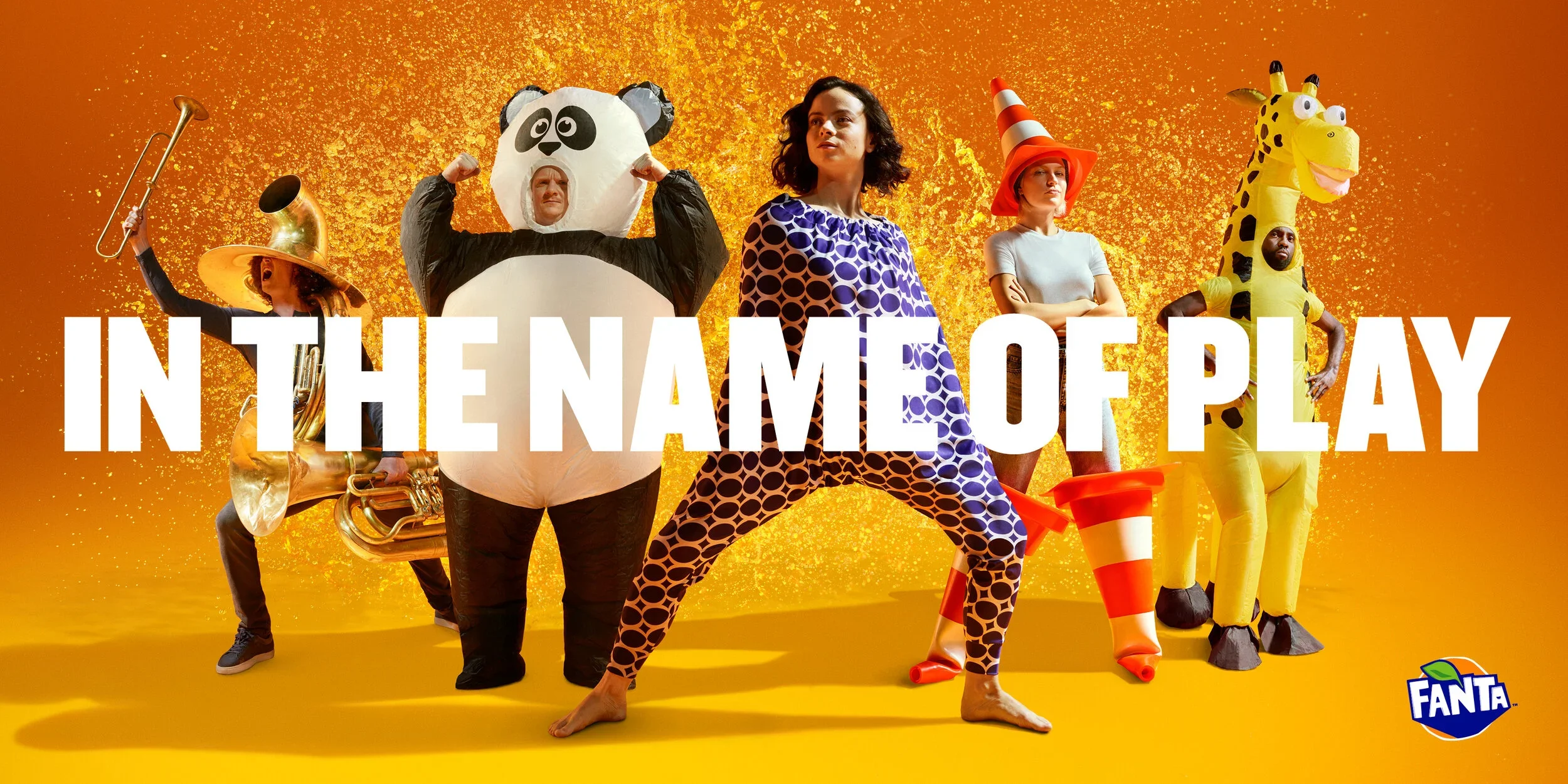Group of five people in colorful costumes with a yellow and orange background, large white text reading 'In the Name of Play,' and a small Fanta logo in the bottom right corner.