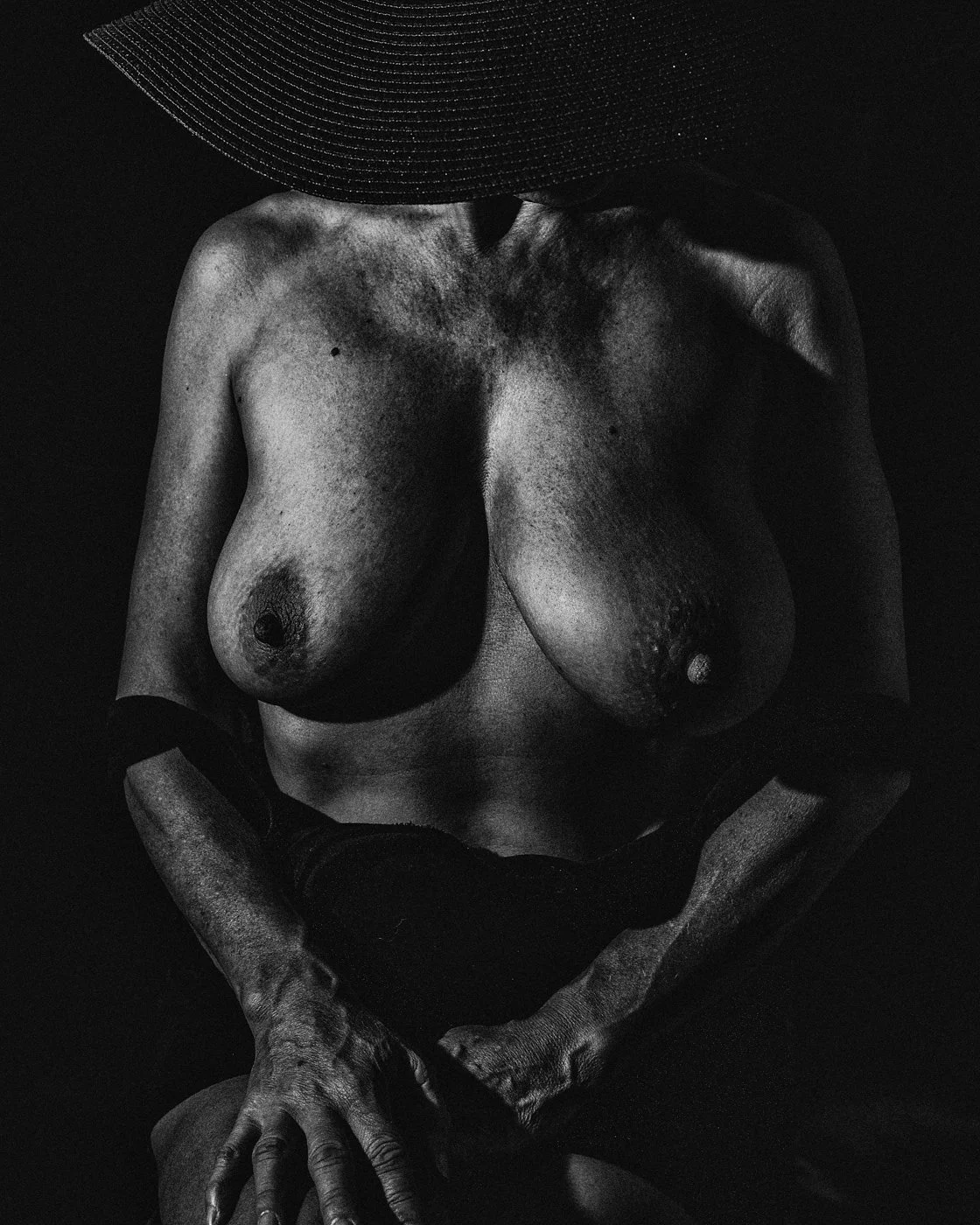 Womain with Black Hat - frontal view with hands on lap.