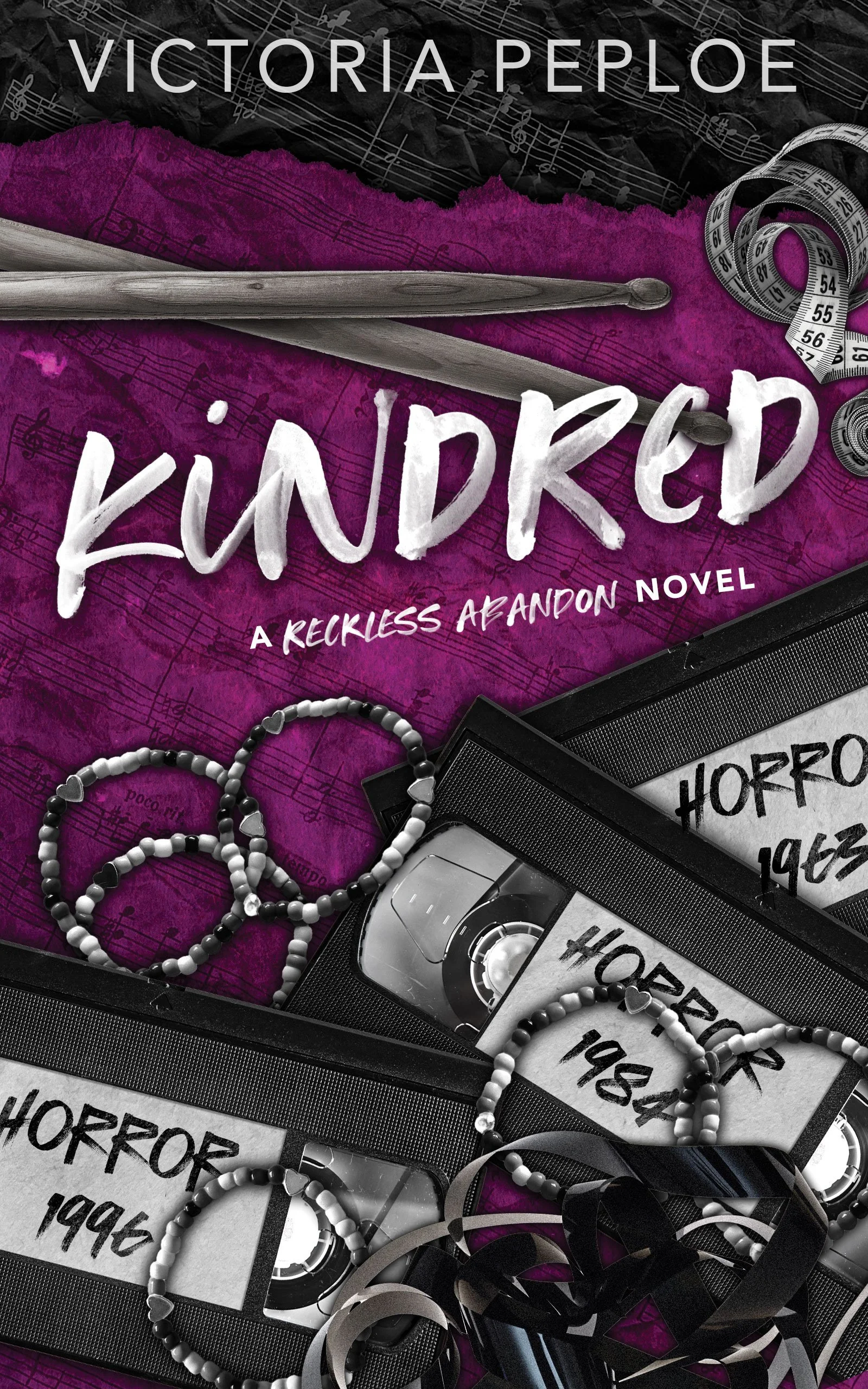 Discreet paperback cover of Kindred by Victoria Peploe. A purple background with a pair of drumsticks, cloth measuring tapes, horror movie VHS tapes, and Black and white beaded friendship bracelets.