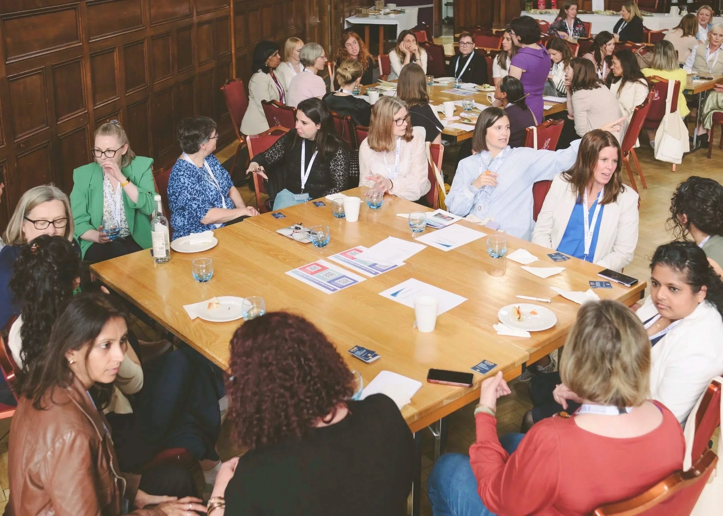 photo showing people sitting around two tables and chatting to each other