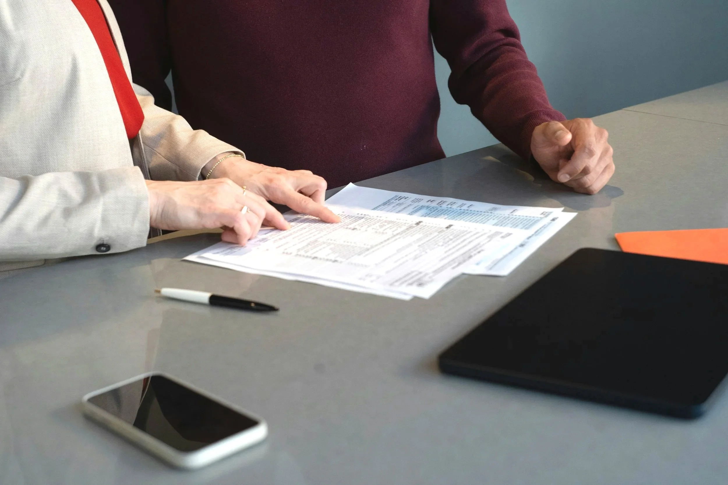 two people looking down at paperwork