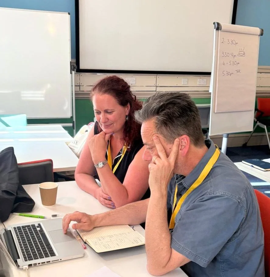 Two people working together and looking at a laptop screen