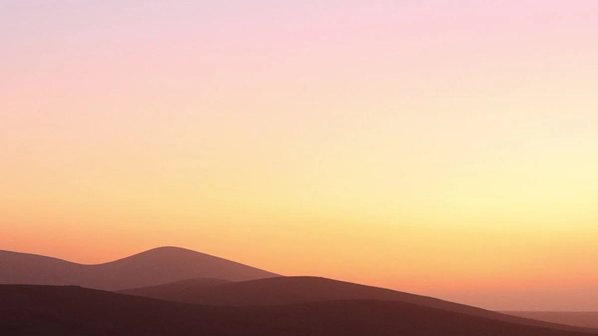 Minimalistische, geschwungene Berge im Sonnenuntergang am Rand der Wüste.