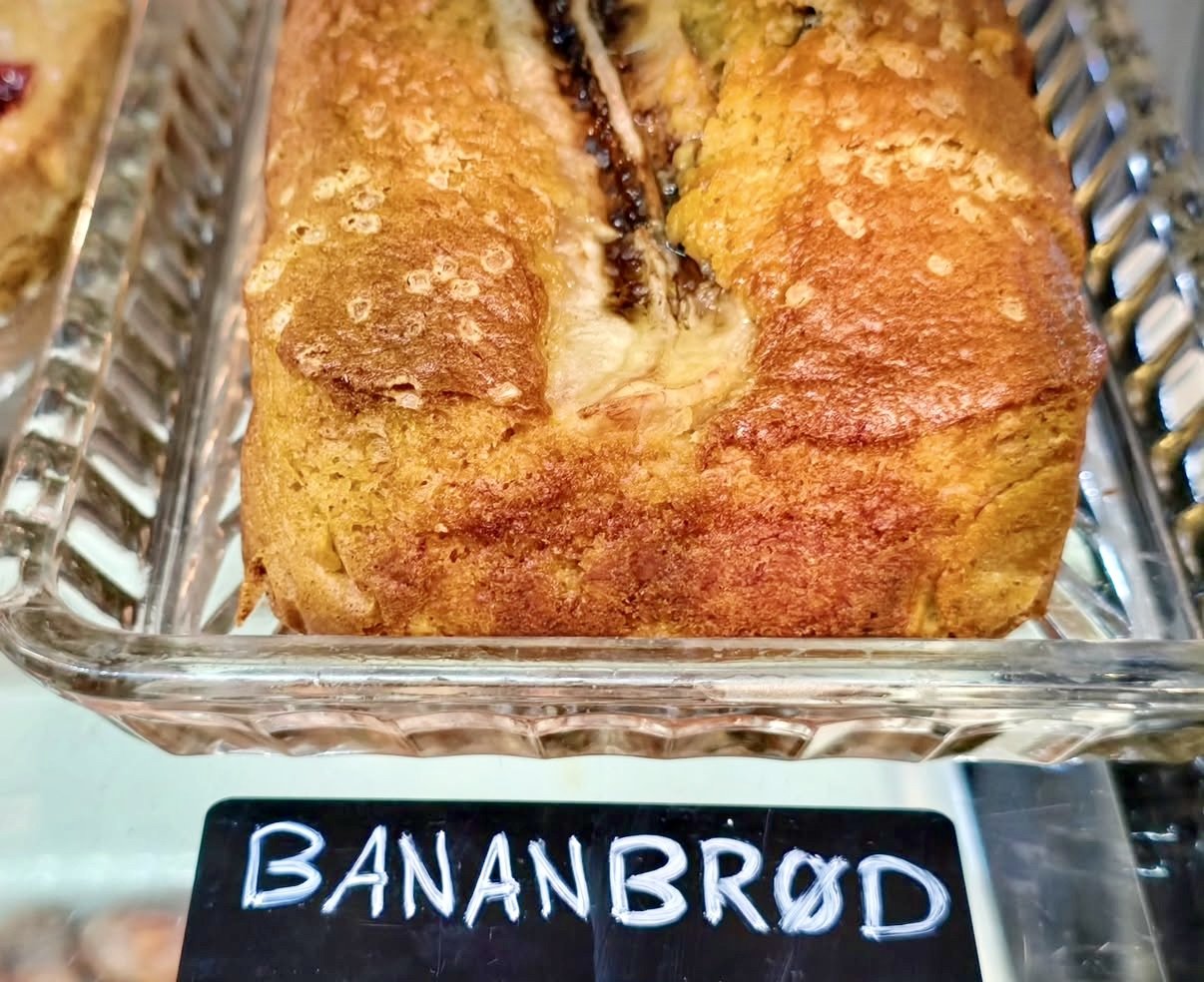 A loaf of banana bread inside a glass baking dish with a black label reading 'BANANBREAD'