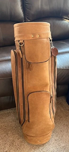 Handmade tan full-grain leather golf bag with shoulder strap, side pockets, and front zip pocket, handcrafted premium leather golf carry bag