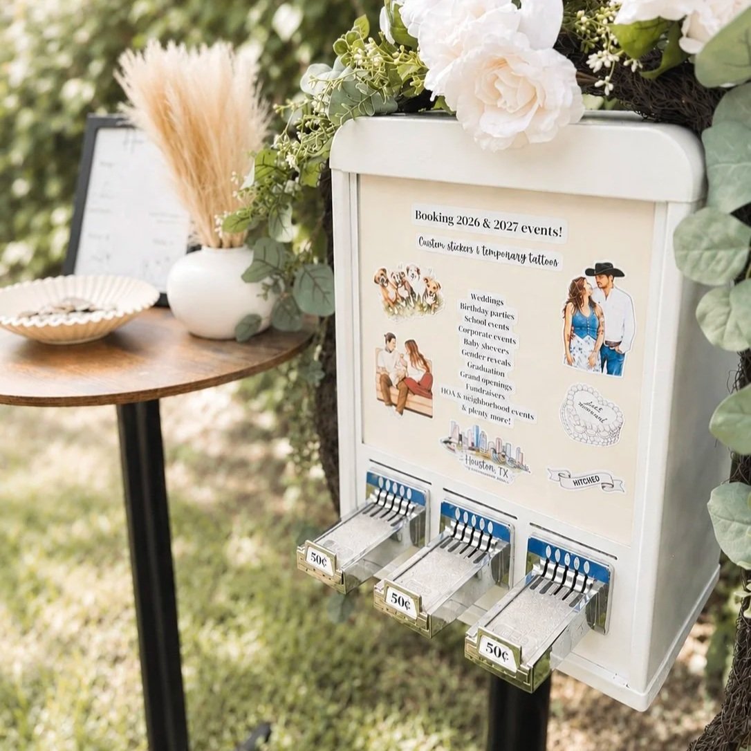A coin-operated tip jar stand decorated with flowers and ready for payment, advertising booking events and custom tattoos, with illustrations of people and a city skyline on it.