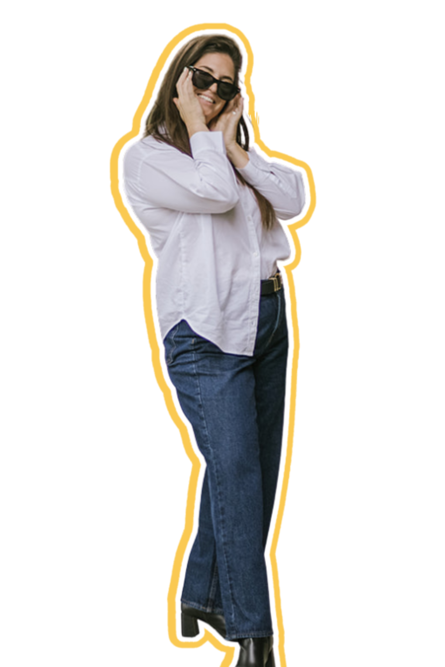 Woman with long brown hair wearing a white shirt, blue jeans, black ankle boots, and sunglasses, smiling and posing with her hands near her face.
