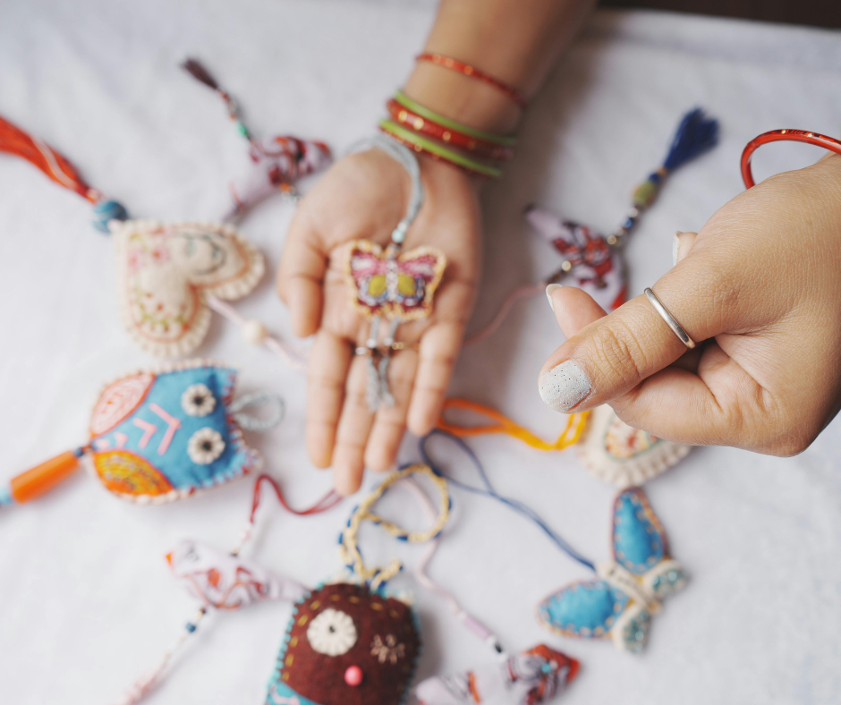 Hand holding handmade jewelry at a craft fair.