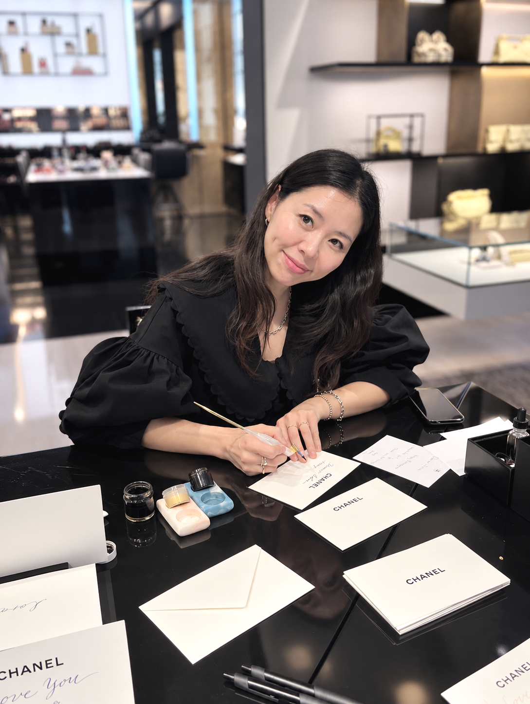 Live calligraphy artist providing luxury brand personalization at a Chanel event in Los Angeles, California.