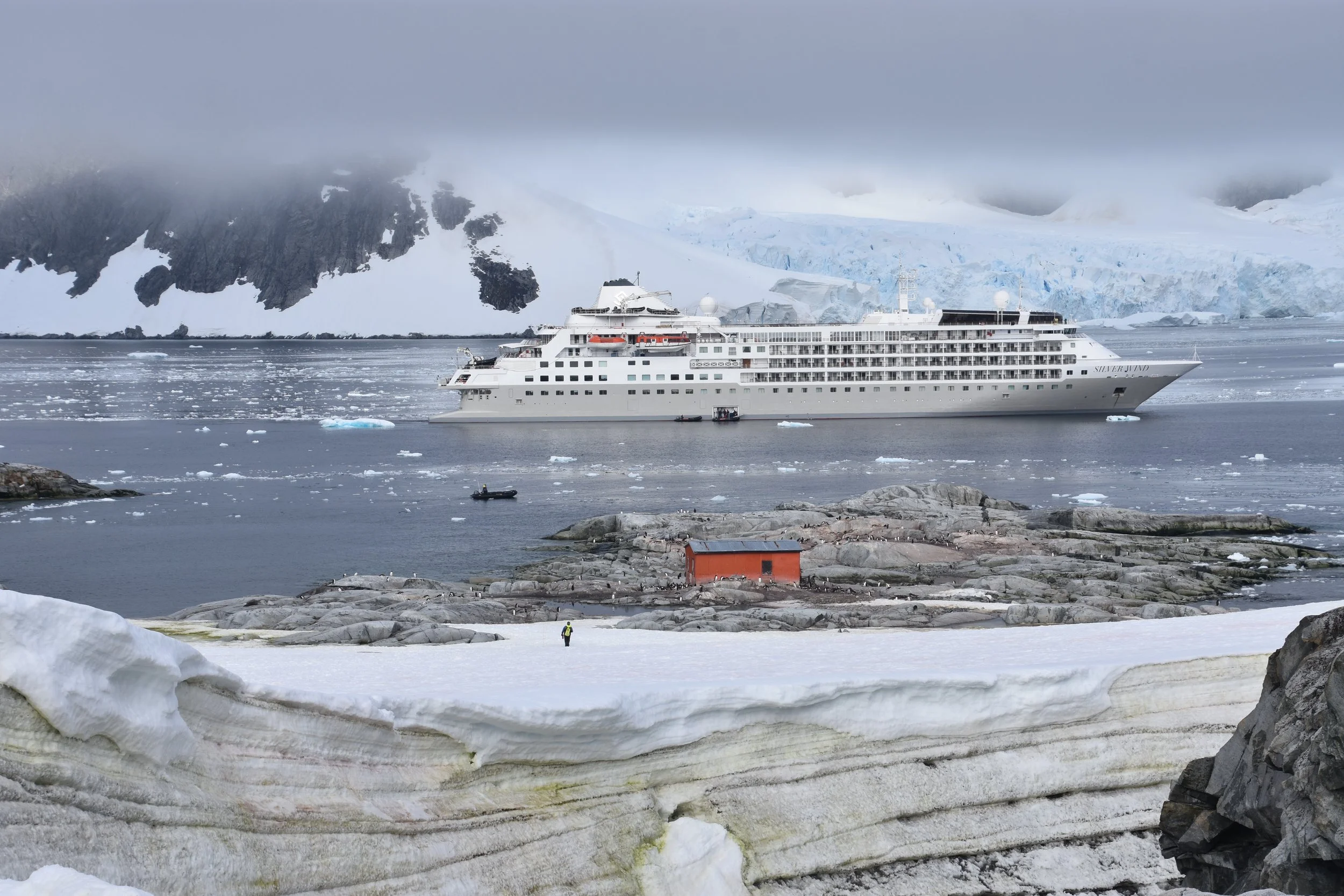 Silversea expedition ship anchored off the snowy coast of Antarctica